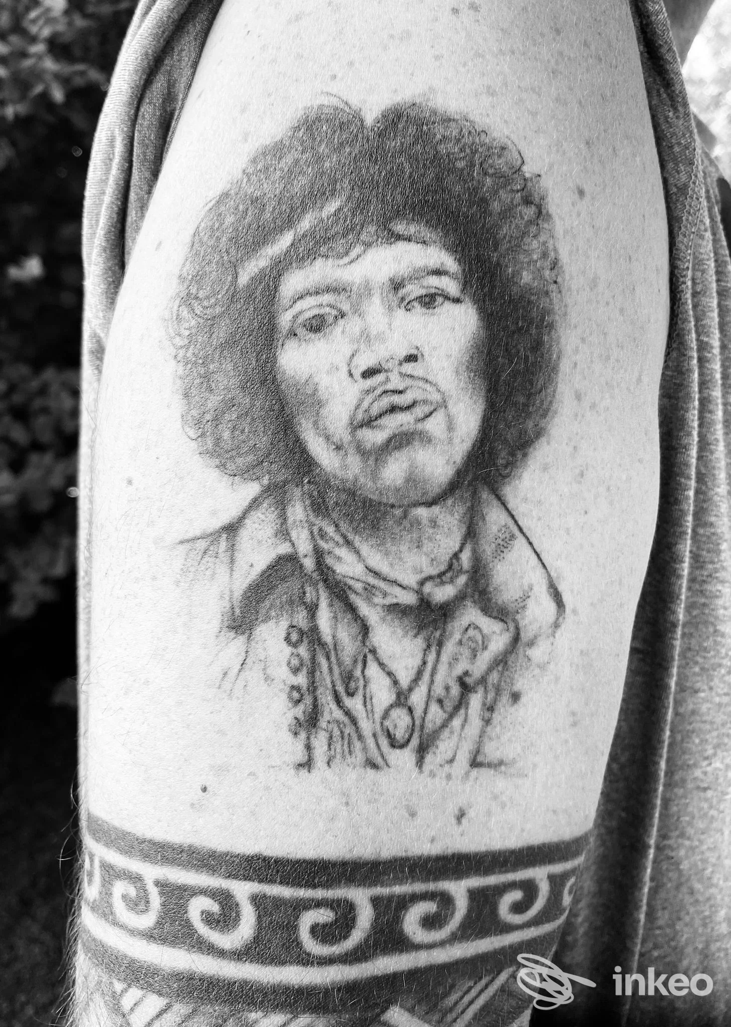 Ritratto tatuato in bianco e nero sul braccio superiore, dettaglio del tatuaggio realizzato da Punto Luce Tattoo a Caselle.