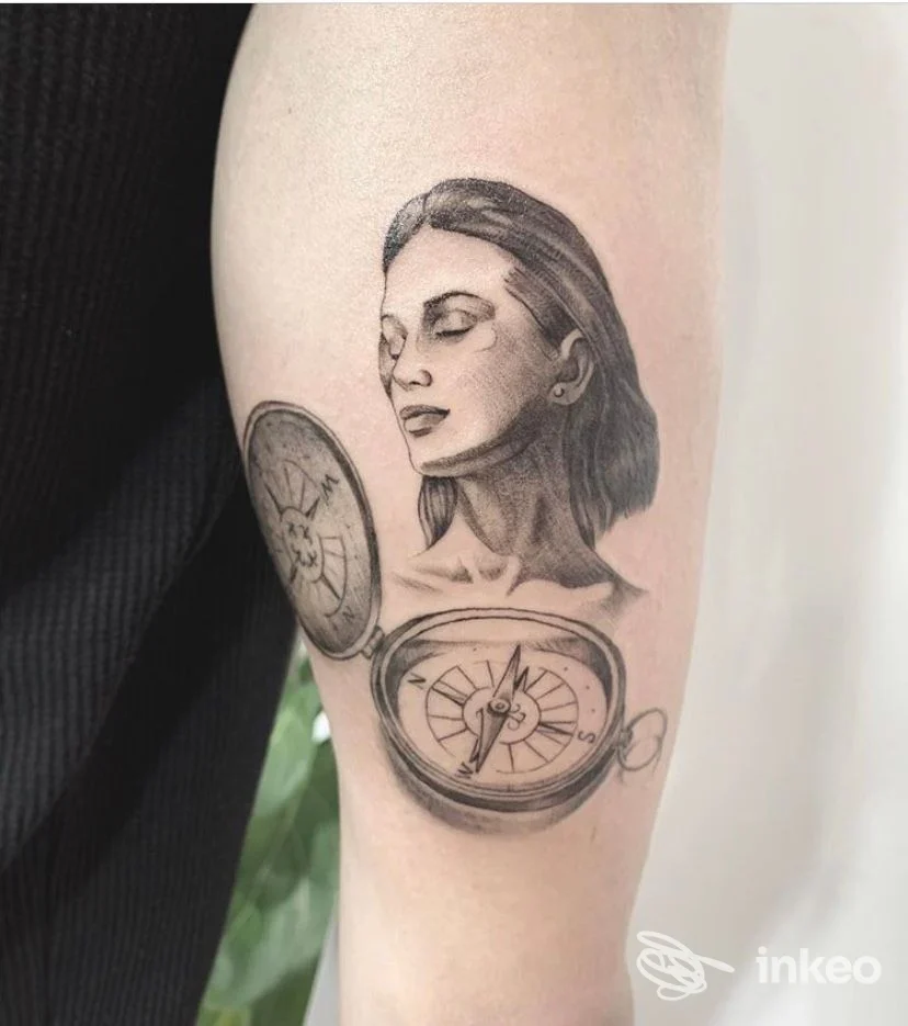 Tatuaggio in bianco e nero su avambraccio con ritratto femminile e due bussole, Sara Blink Tattoo, Belluno.