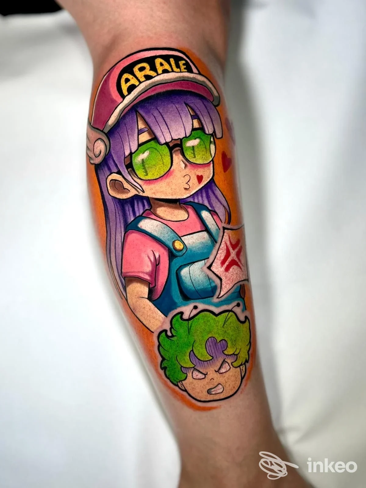 Tatuaggio colorato su avambraccio con personaggio 'Arale' e piccolo volto verde, Senza tempo tattoo, Stra.