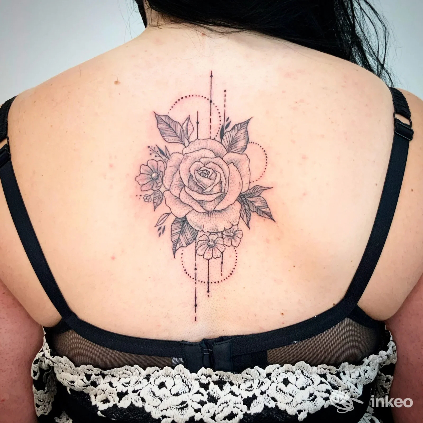 Tatuaggio a rosa in bianco e nero al centro della schiena, linee sottili e puntinato; lavoro di Silvietta tattoo a Soave.