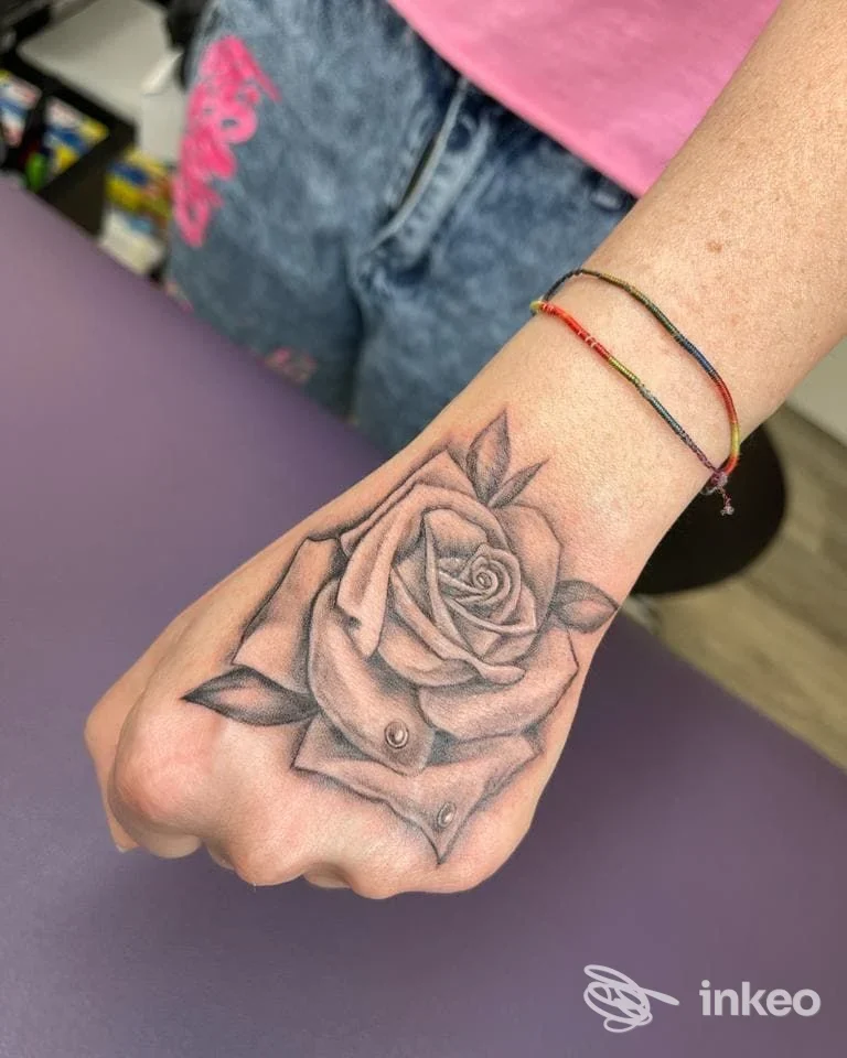 Tatuaggio realistico di una rosa in bianco e nero sul dorso della mano, fotografato presso Sottopelle Tattoo Studio a Romano d'Ezzelino.