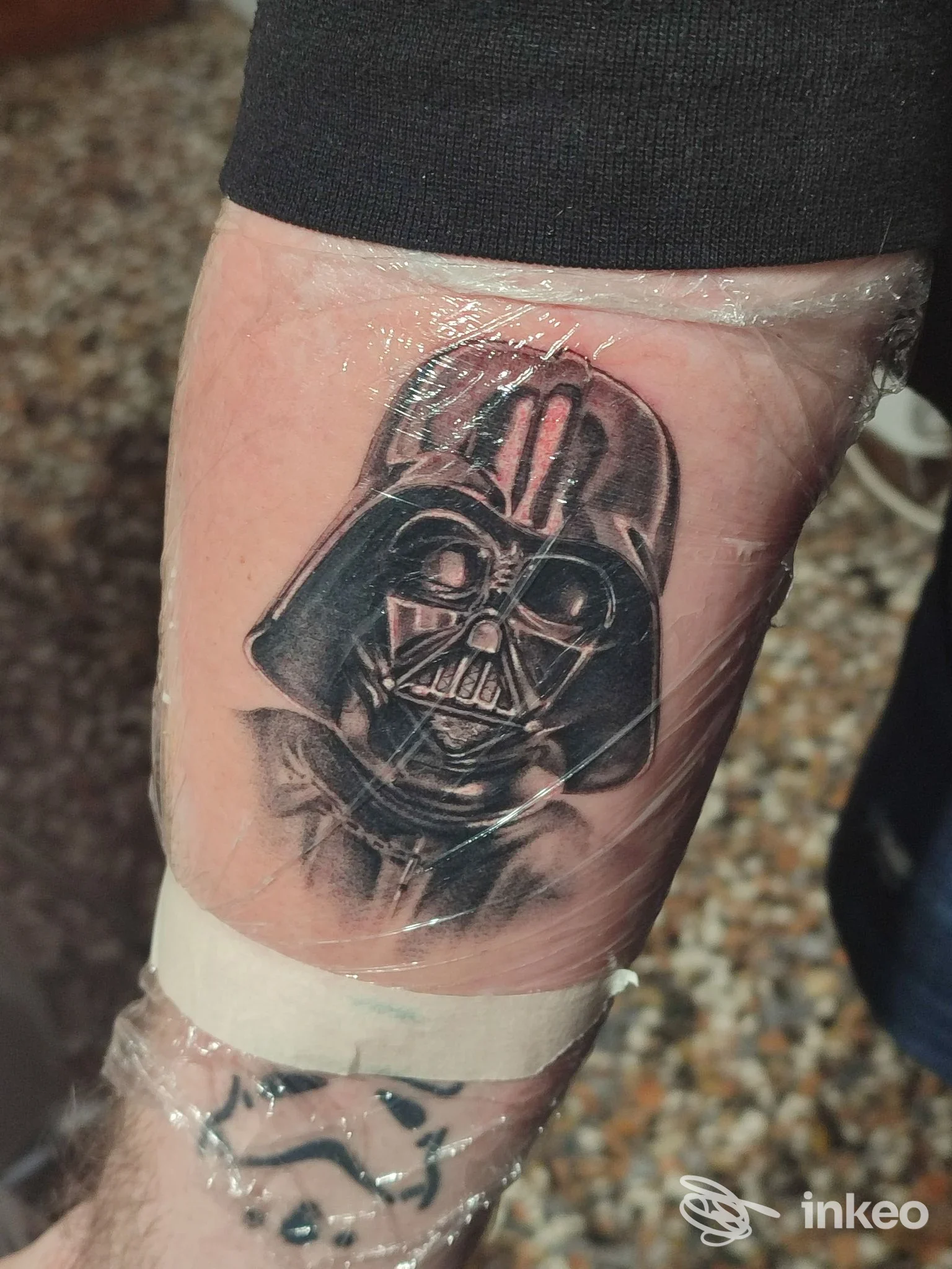 Tatuaggio fresco raffigurante il casco di un personaggio sull'avambraccio, avvolto nella pellicola; Sourya Tattoo Studio, Marghera.