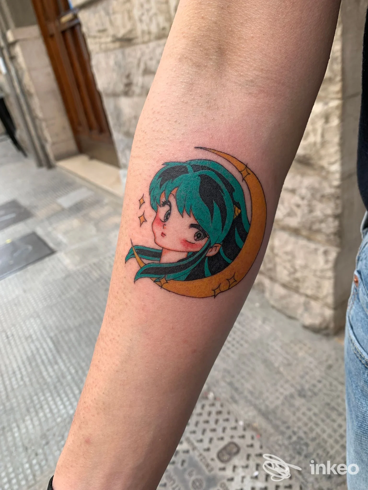 Tatuaggio su avambraccio raffigurante un volto in stile anime inserito in una luna; foto inviata da Sourya Tattoo Studio, Marghera.