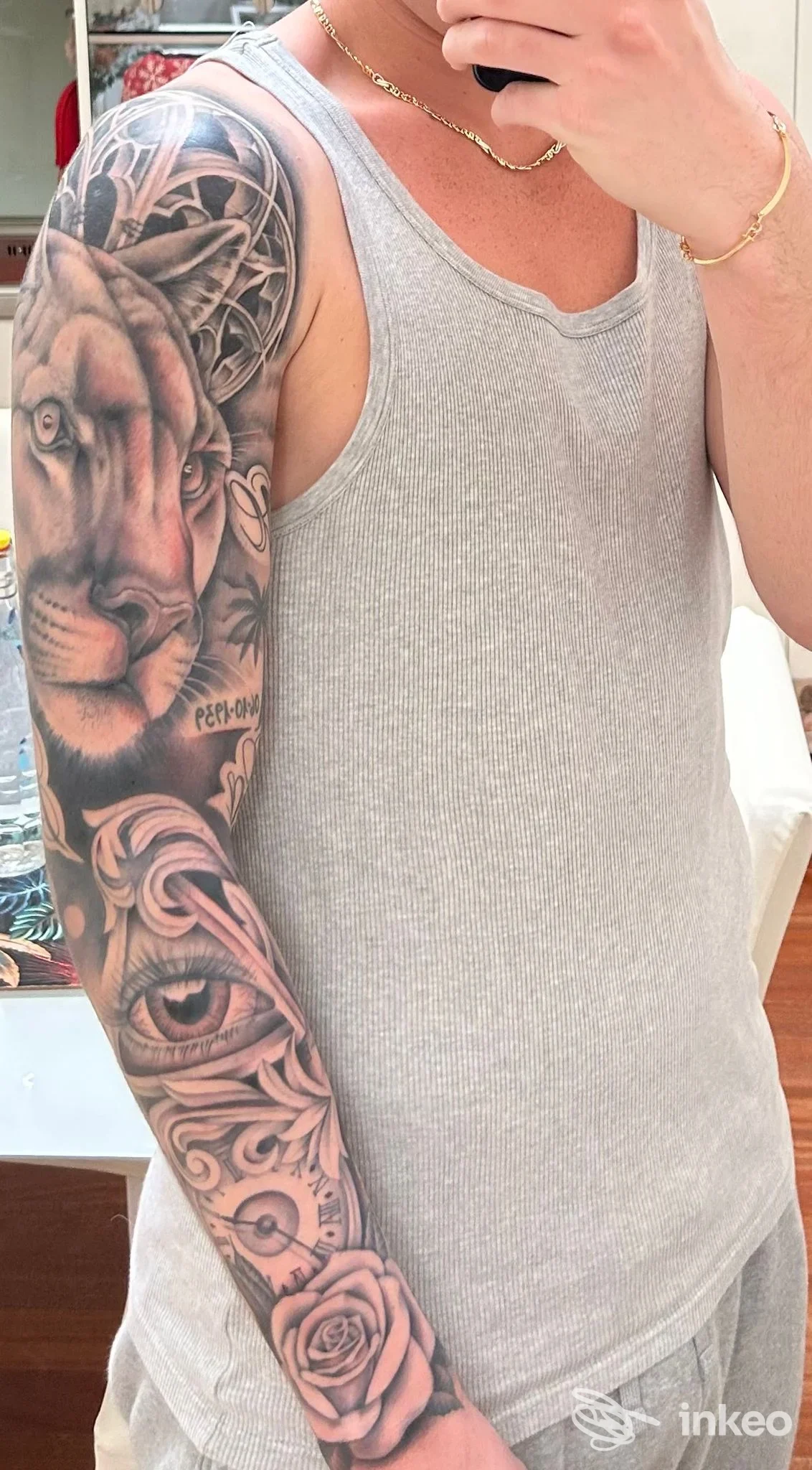 Manica tatuata in bianco e nero con leone, occhio e rosa sul braccio destro, foto per Tattoo Consortium a Venezia.