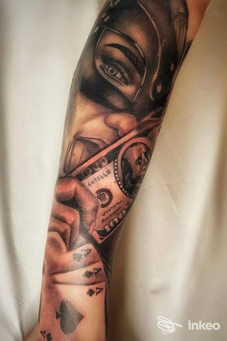 Manica tatuata realistico black & grey su avambraccio, volto mascherato, banconota e carte. The Godfather Tattoo, Villafranca di Verona.