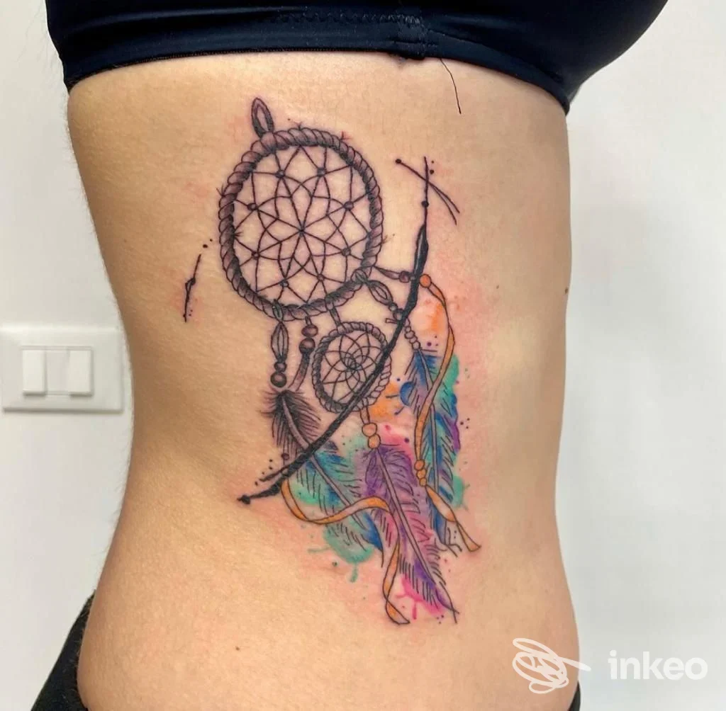 Tatuaggio dreamcatcher colorato sul fianco, lavoro realizzato da Tattoo Utopia a Verona, dettagli con penne e acquerello.
