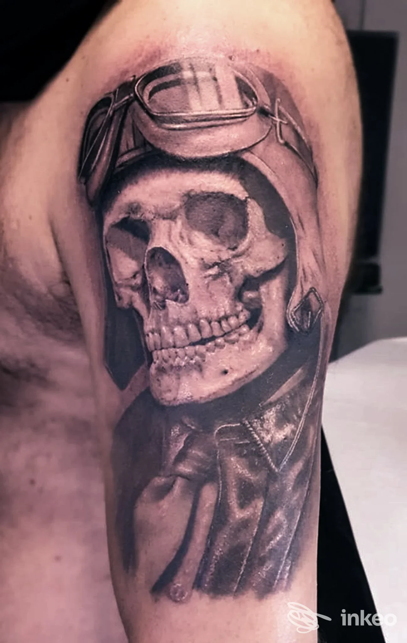Tatuaggio in bianco e nero di un teschio con casco da pilota sul braccio superiore, Tribal Spirit Tattoo & Art Studio, Castelfranco Veneto.