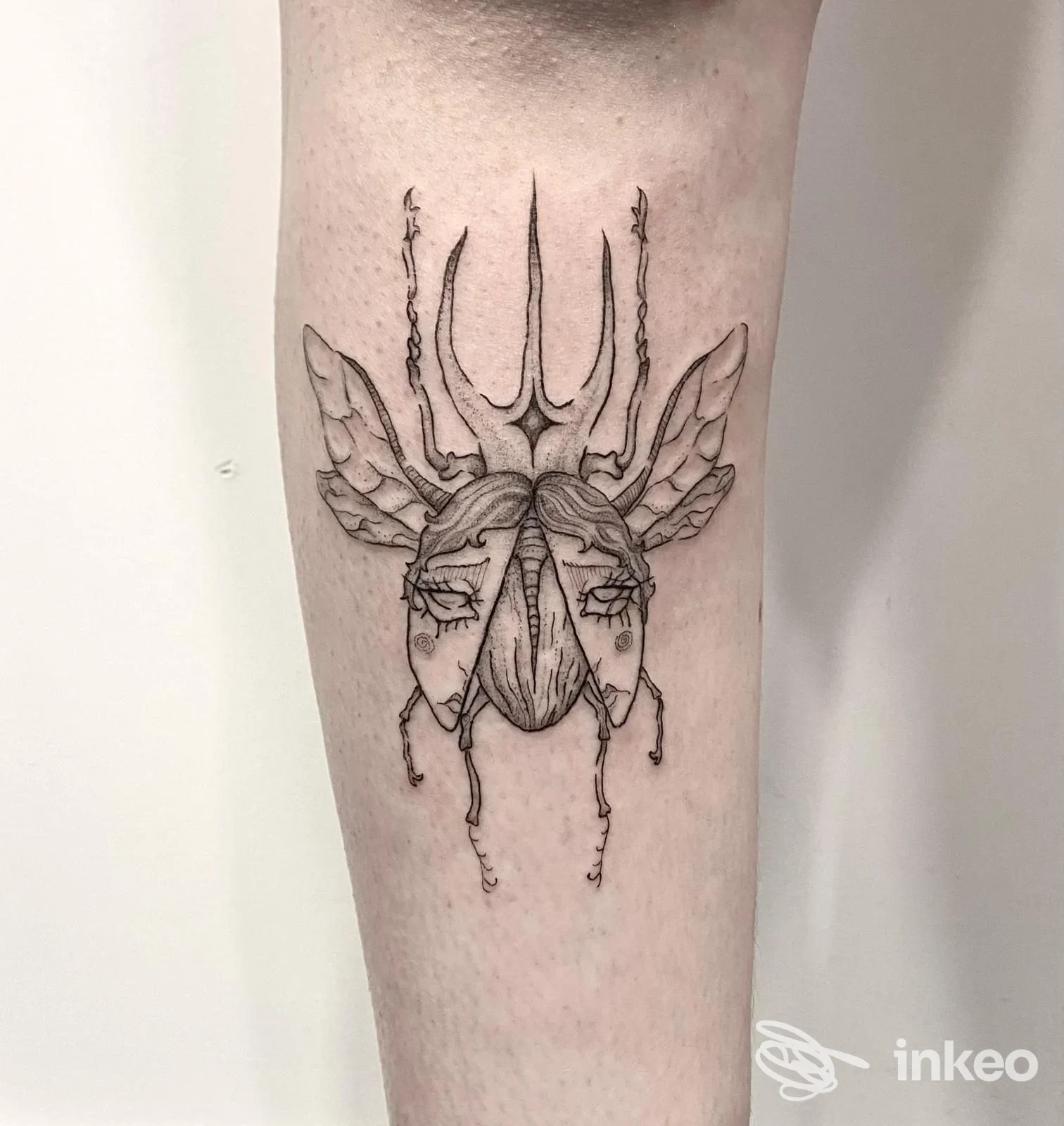Tatuaggio in bianco e nero su avambraccio: insetto stilizzato con tratti facciali, The Rabbit Hole Tattoo&Jewelry, Verona.