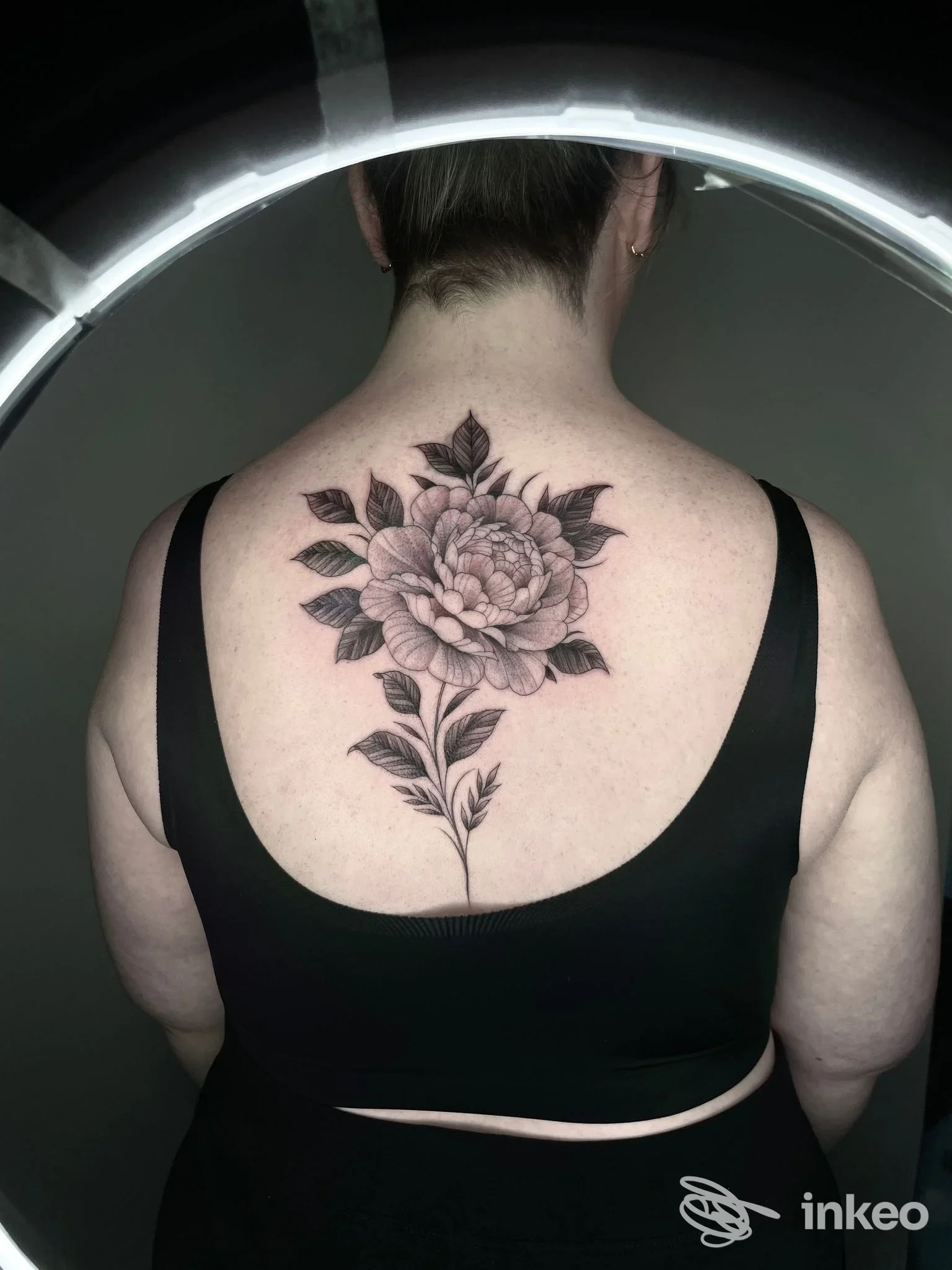 Grande tatuaggio floreale in nero e grigio sulla parte superiore della schiena, fotografato nello studio Twin Flame tattoo lab a Rubano.