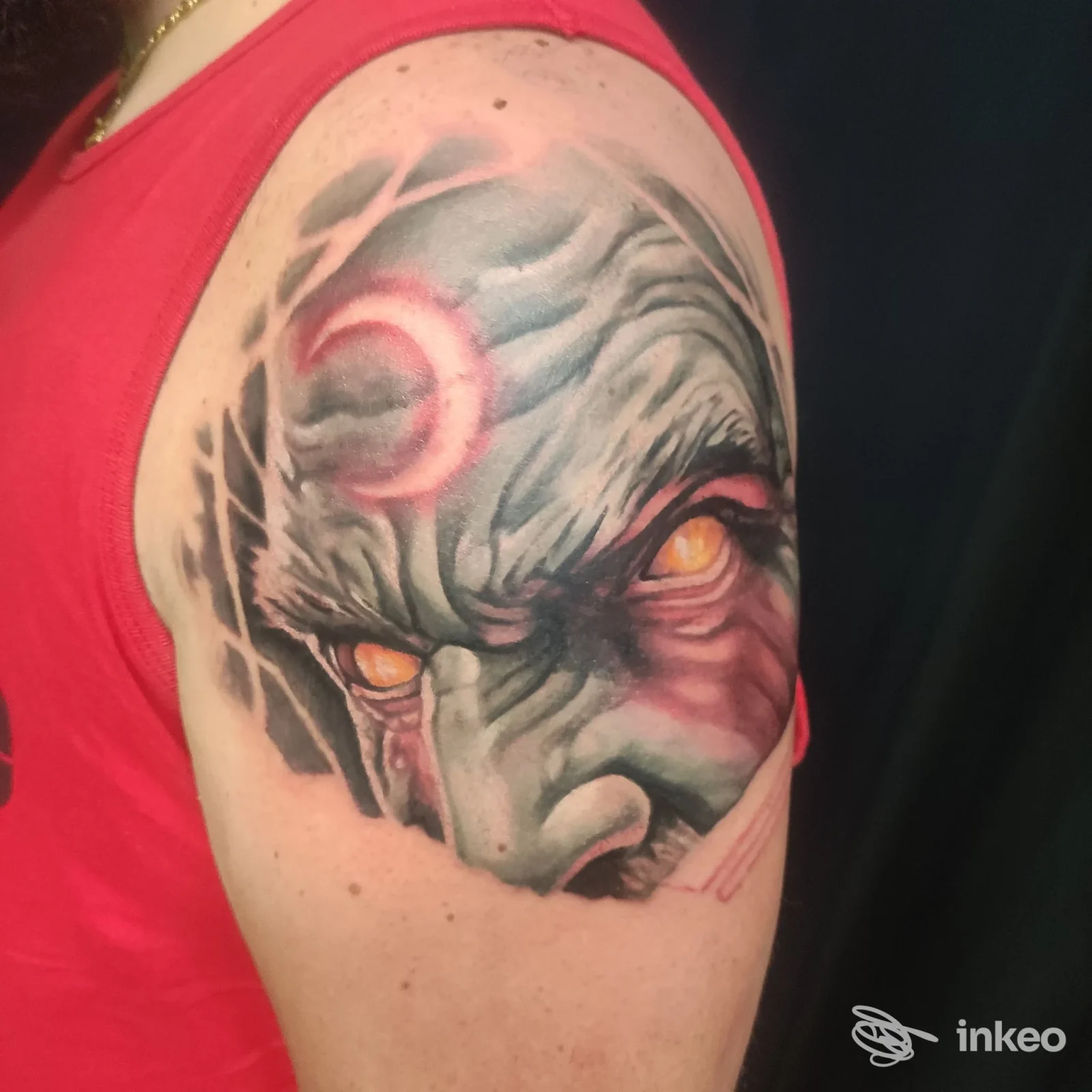 Tatuaggio realistico su spalla e alto braccio realizzato da Arte Viva Tattoo e Piercing Studio, Vicenza: volto colorato con occhi gialli e mezzaluna rosa.