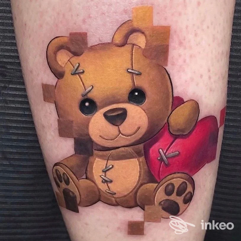 Tatuaggio di un orsetto giocattolo marrone con cuore rosso sul polpaccio, lavoro colorato ben fatto. BLOODLINE TATTOO PIERCING, Castelfranco Veneto.
