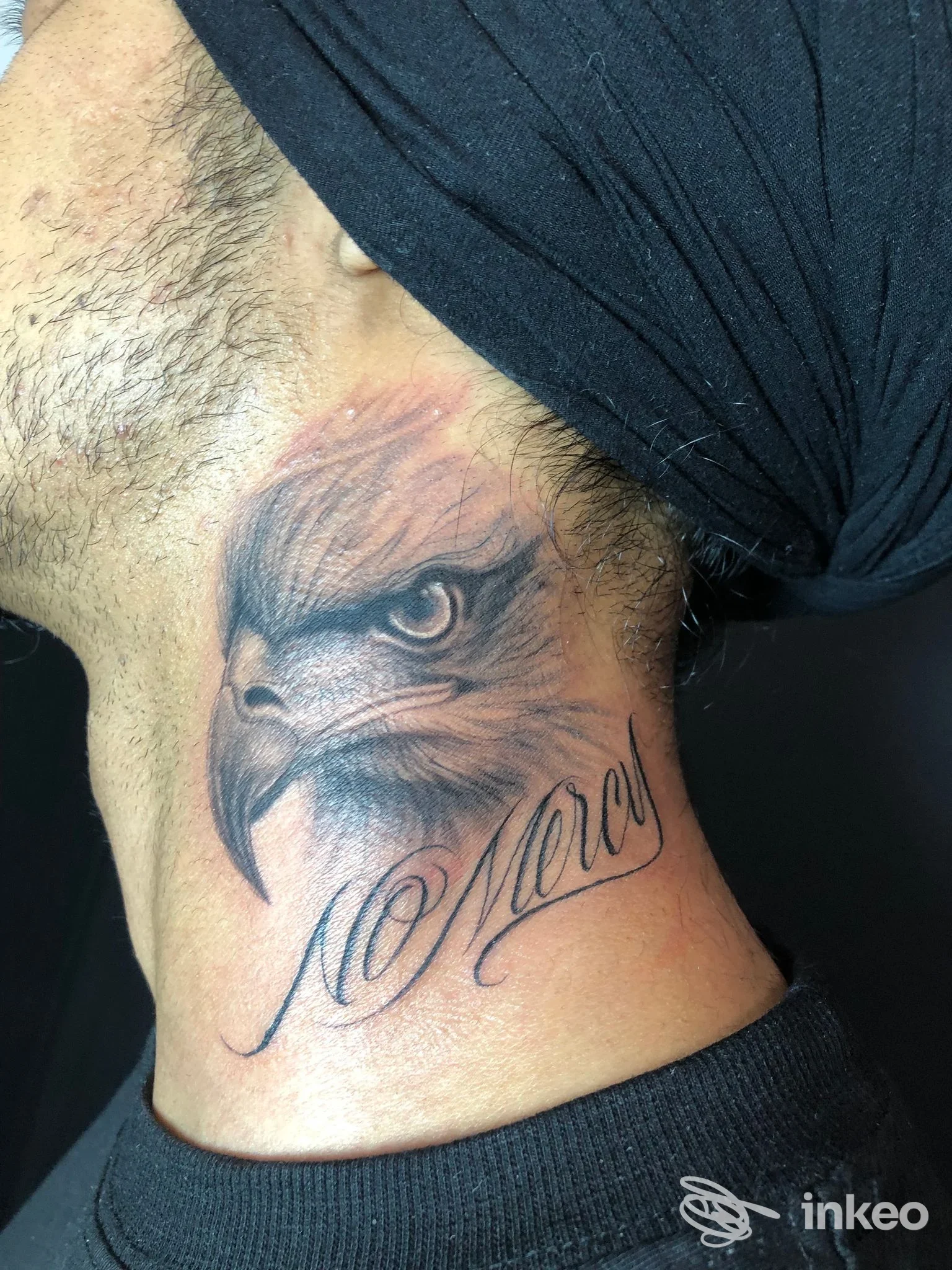 Dettaglio di tatuaggio a collo con testa di aquila e scritta corsiva, scatto dallo studio Barnum tattoos & body art di Cerea.
