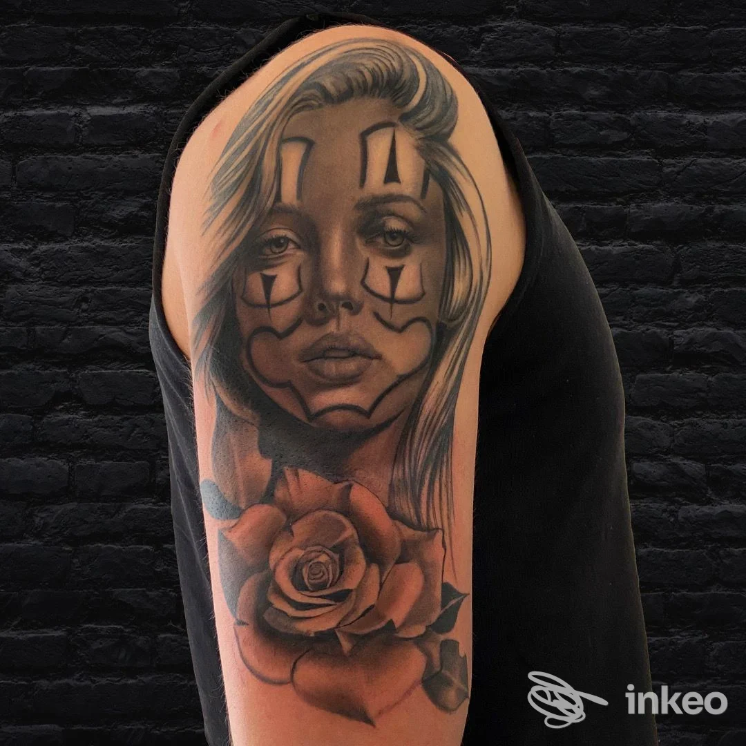 Tatuaggio realistico su spalla e bicipite con volto femminile in stile clown e rosa, Black Wire Tattoo Mirano.