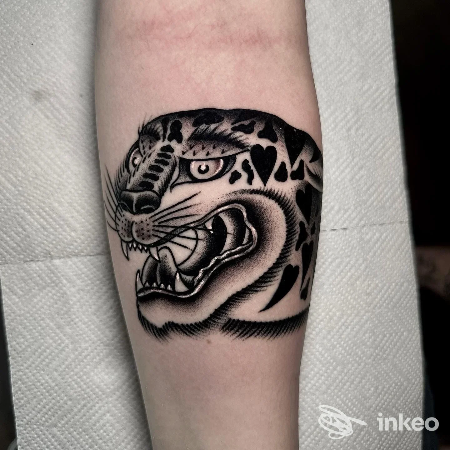 Tattoo leopardato in bianco e nero sull’avambraccio, con dettagli di shading e denti vistosi.