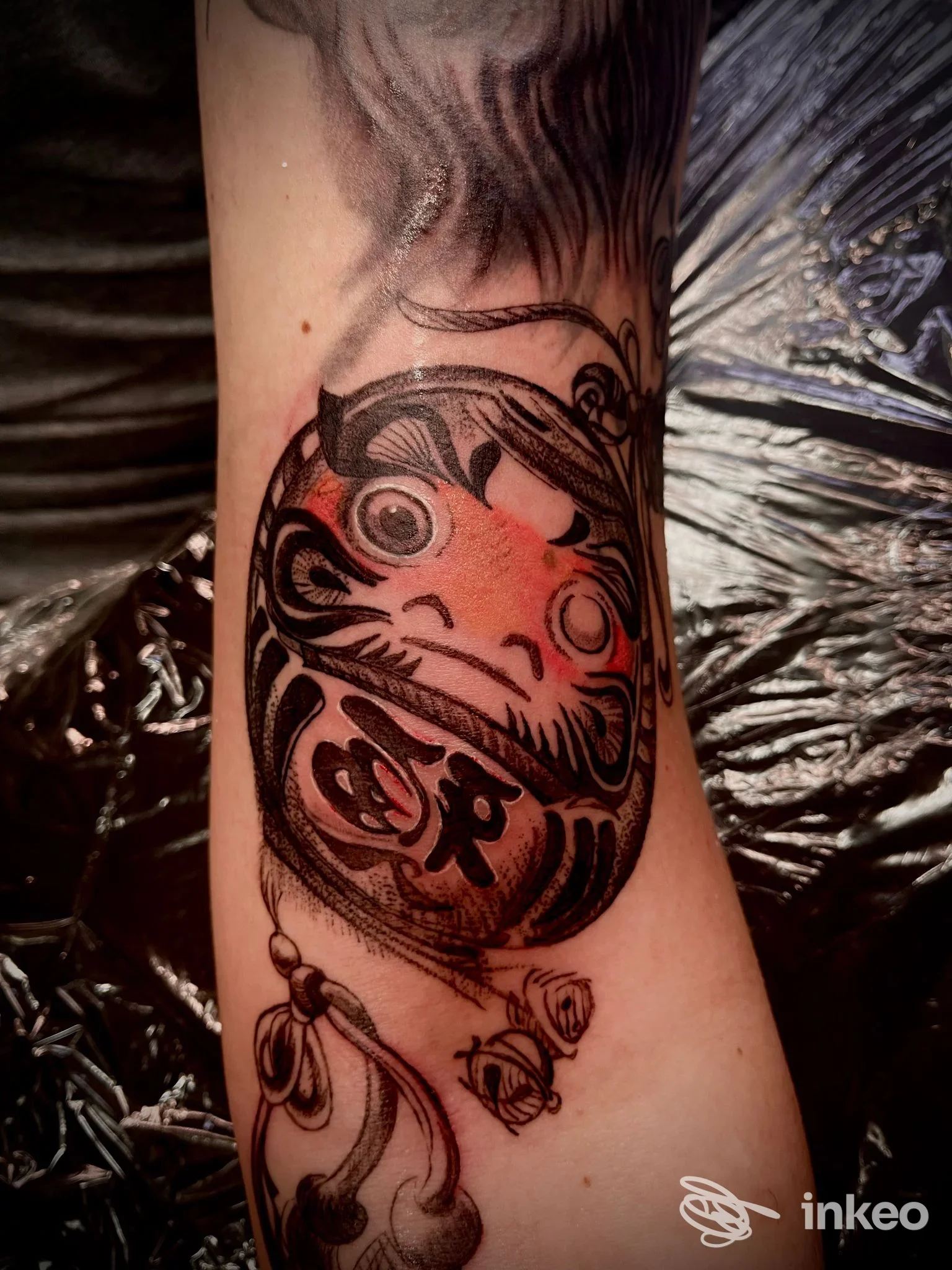 Tatuaggio Daruma sull'avambraccio eseguito da Candy Tattoo Shop, Santorso. Pelle leggermente arrossata dopo la seduta.