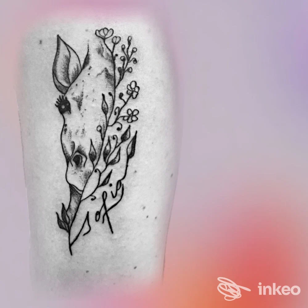 Tatuaggio blackwork raffigurante un cranio animale con rami e piccoli fiori sul lato interno dell'avambraccio, realizzato da Candy Tattoo Shop a Santorso.