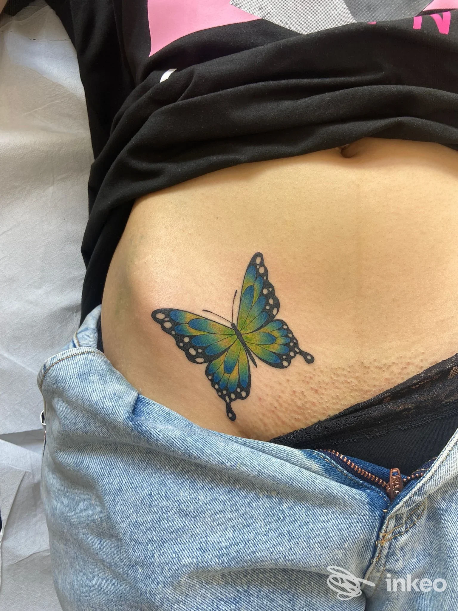 Farfalla colorata tatuata sulla parte bassa dell'addome, fotografia realizzata per Cicatrici d'Inchiostro Walk-In Tattoo Studio, Verona.