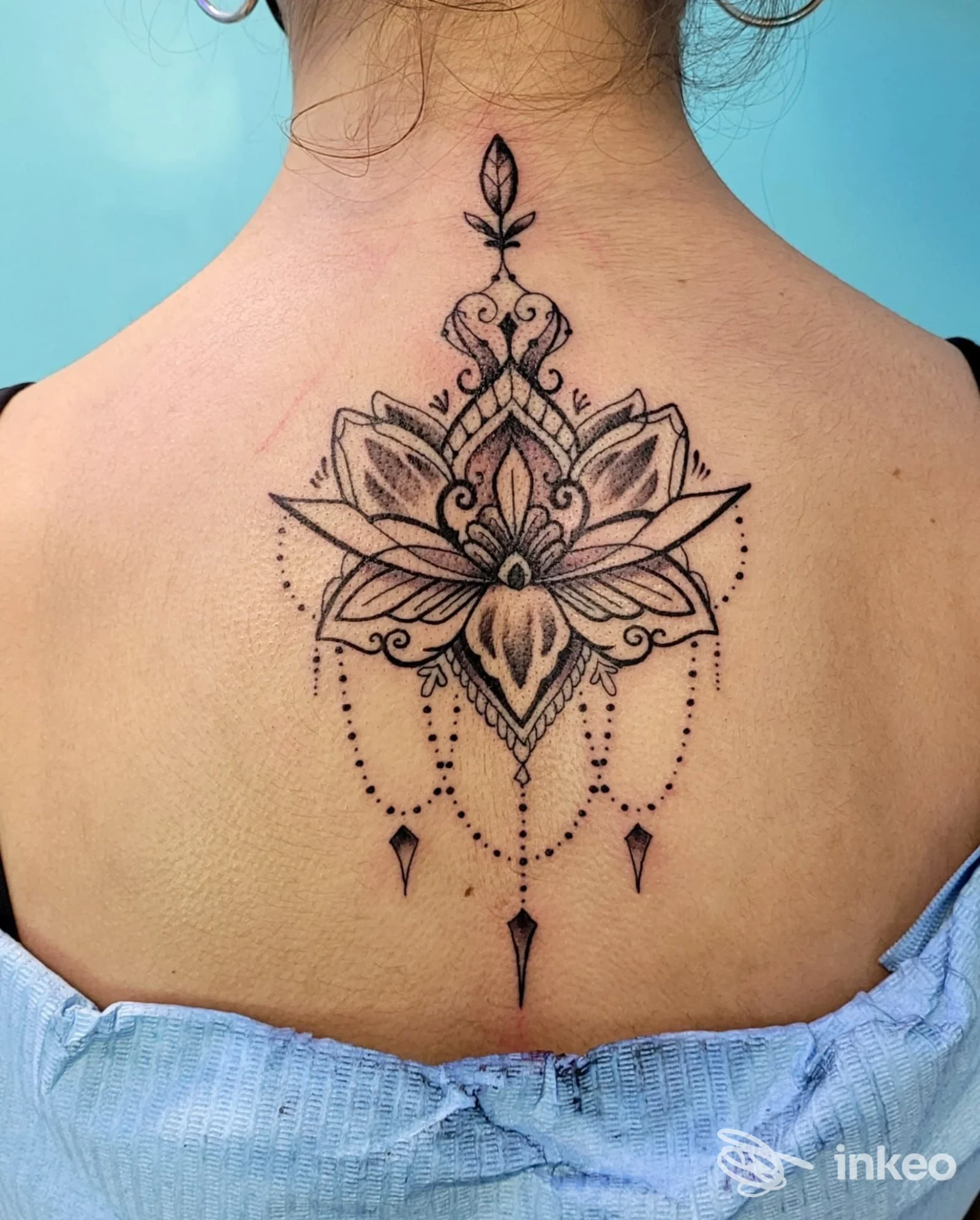Grande tatuaggio ornamentale a mandala sulla parte superiore della schiena, realizzato da Denis Trevisani Tattoo Studio, Cerea.