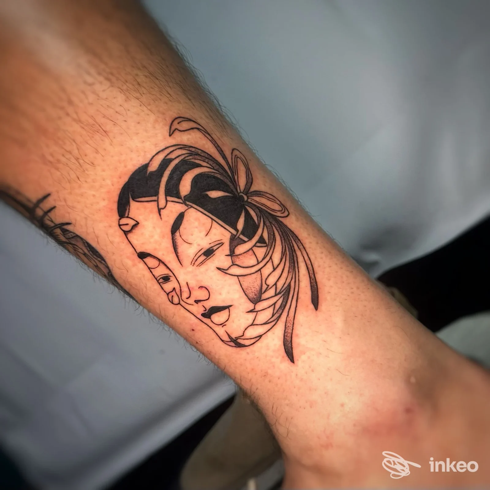 Tatuaggio linework di un volto stilizzato sull'avambraccio, realizzato da Ellie tattoo a Castel d'Azzano.