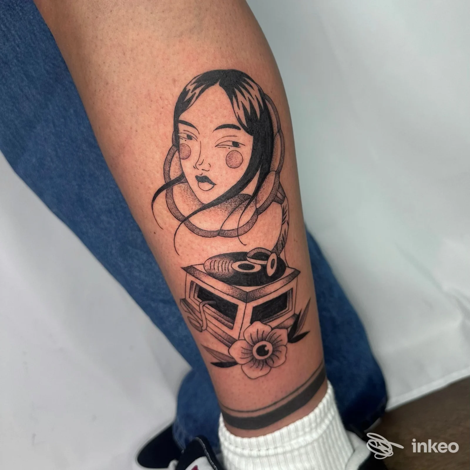 Tatuaggio blackwork su avambraccio con volto stilizzato, grammofono e fiore — Ellie tattoo, Castel d'Azzano.