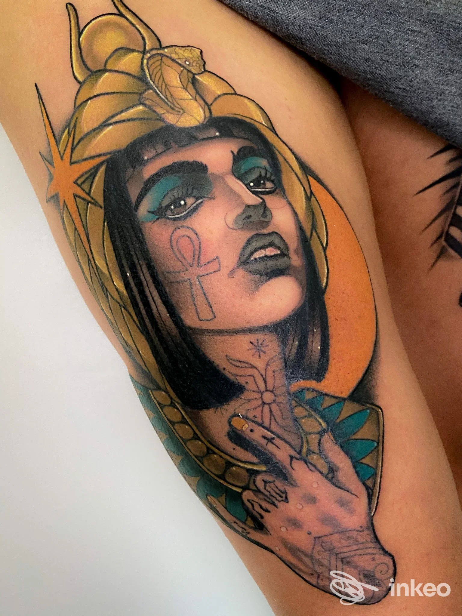 Tatuaggio a colori sul braccio raffigurante un volto femminile con ankh e serpente, Factory Tattoo, Selvazzano Dentro.