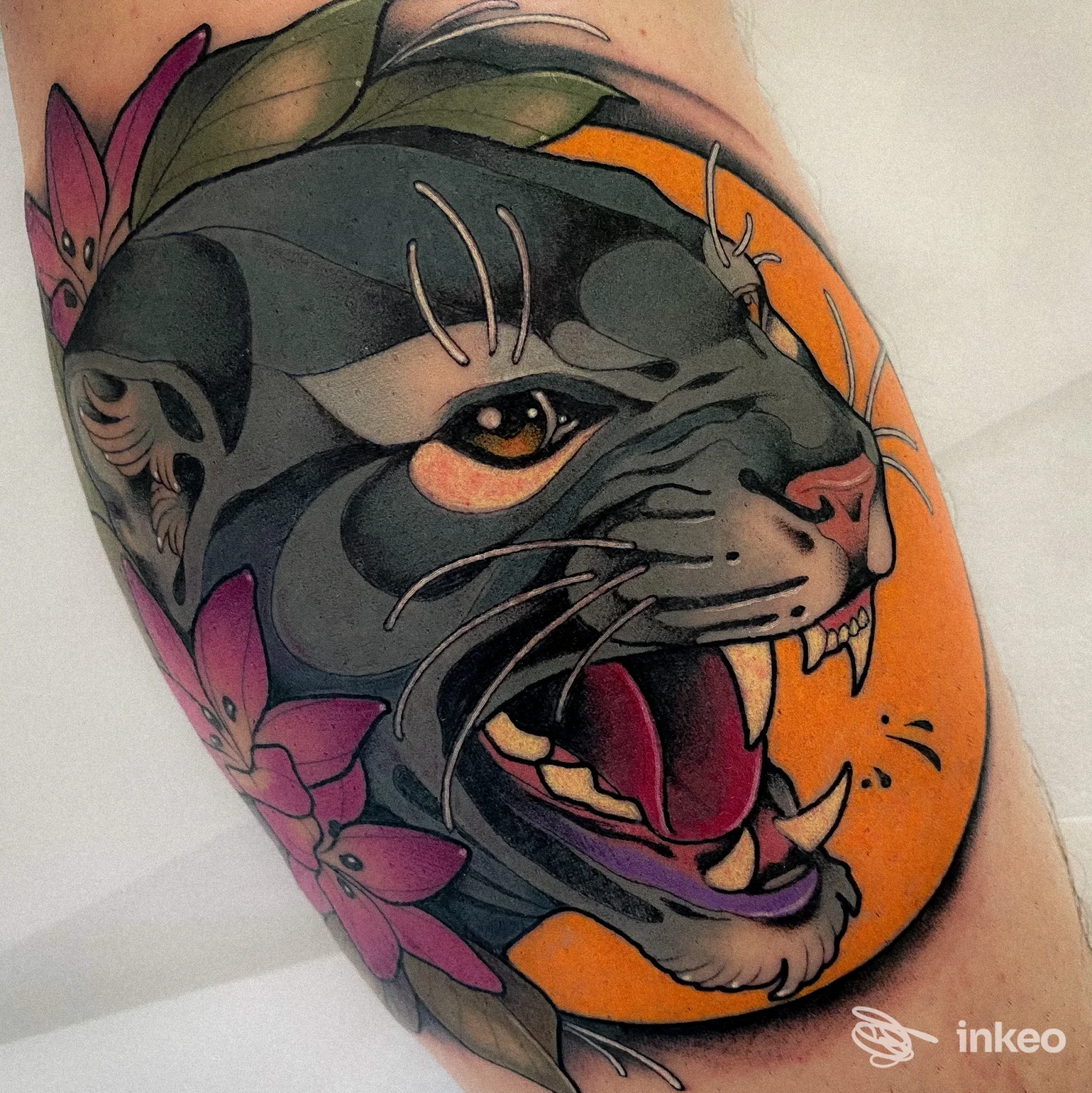 Tatuaggio su avambraccio: testa di pantera con fiori e sfondo arancione, foto inviata da Factory Tattoo, Selvazzano Dentro.