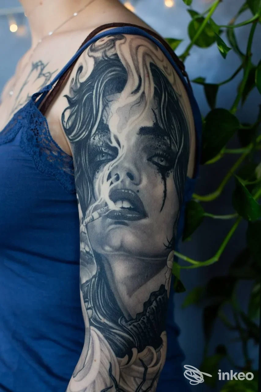 Tatuaggio a manica realistico in bianco e nero sul braccio, ritratto fumoso. In Dreams Tattoo, Montebelluna.