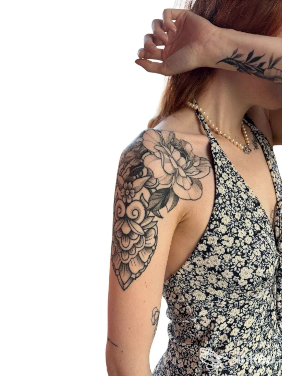 Primo piano di tatuaggio floreale sulla spalla e parte superiore del braccio, foto realizzata da In Dreams Tattoo a Montebelluna.