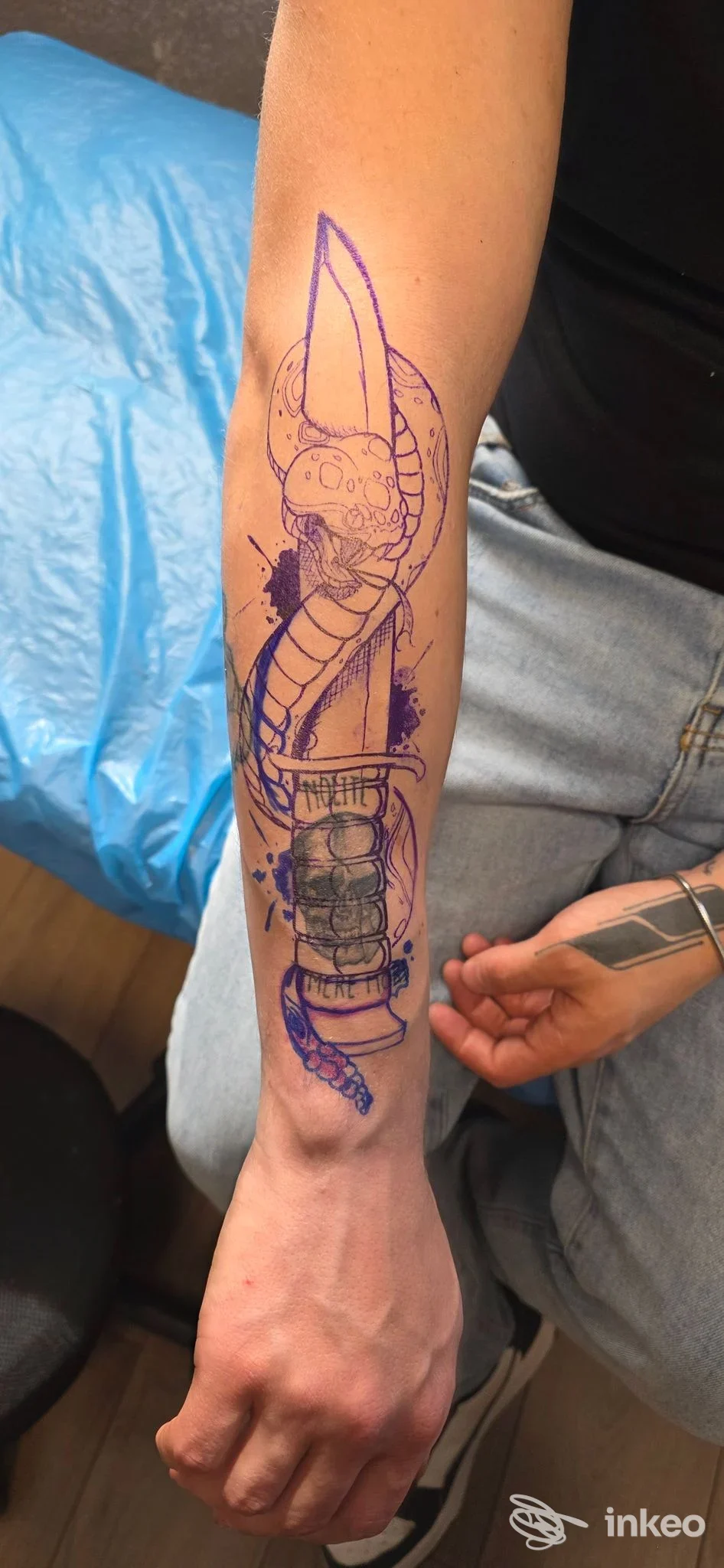 Tatuaggio visibile sull’avambraccio, disegno in linee blu e sfumature viola, realizzo nello studio Scribbles Tattoo a Castano Primo.