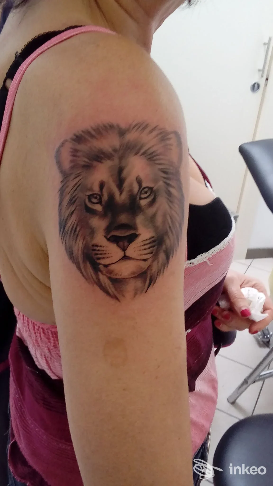 Tatuaggio realistico di testa di leone sull'omero di una cliente eseguito da Indastria Piercing & Tattoo, Padova.