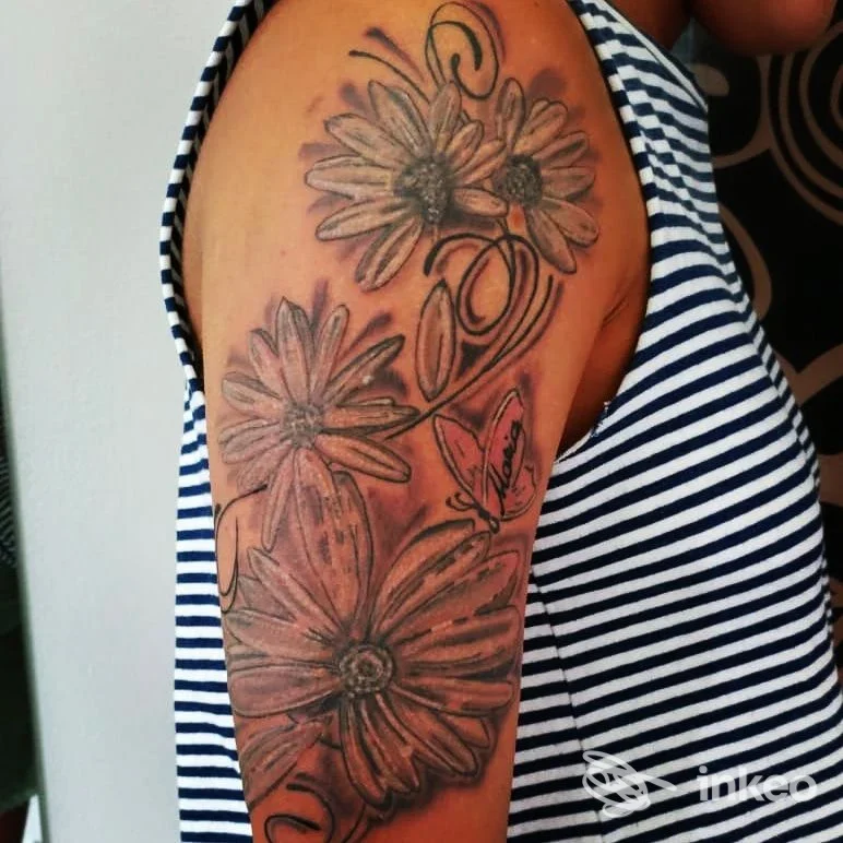 Tatuaggio floreale in nero/grigio sull'omero, foto da Jolie Tattoo Piercing di Luca Marinello a Castelfranco Veneto.