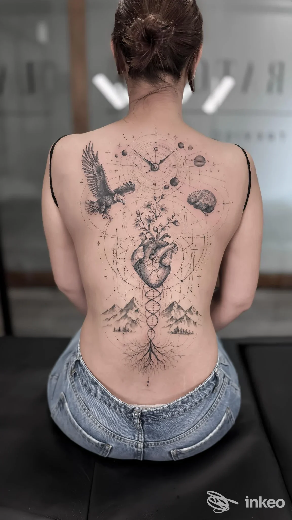 Grande tatuaggio blackwork a tutta schiena mostrato su una persona seduta — LABORATORIO TATTOO, Treviso.