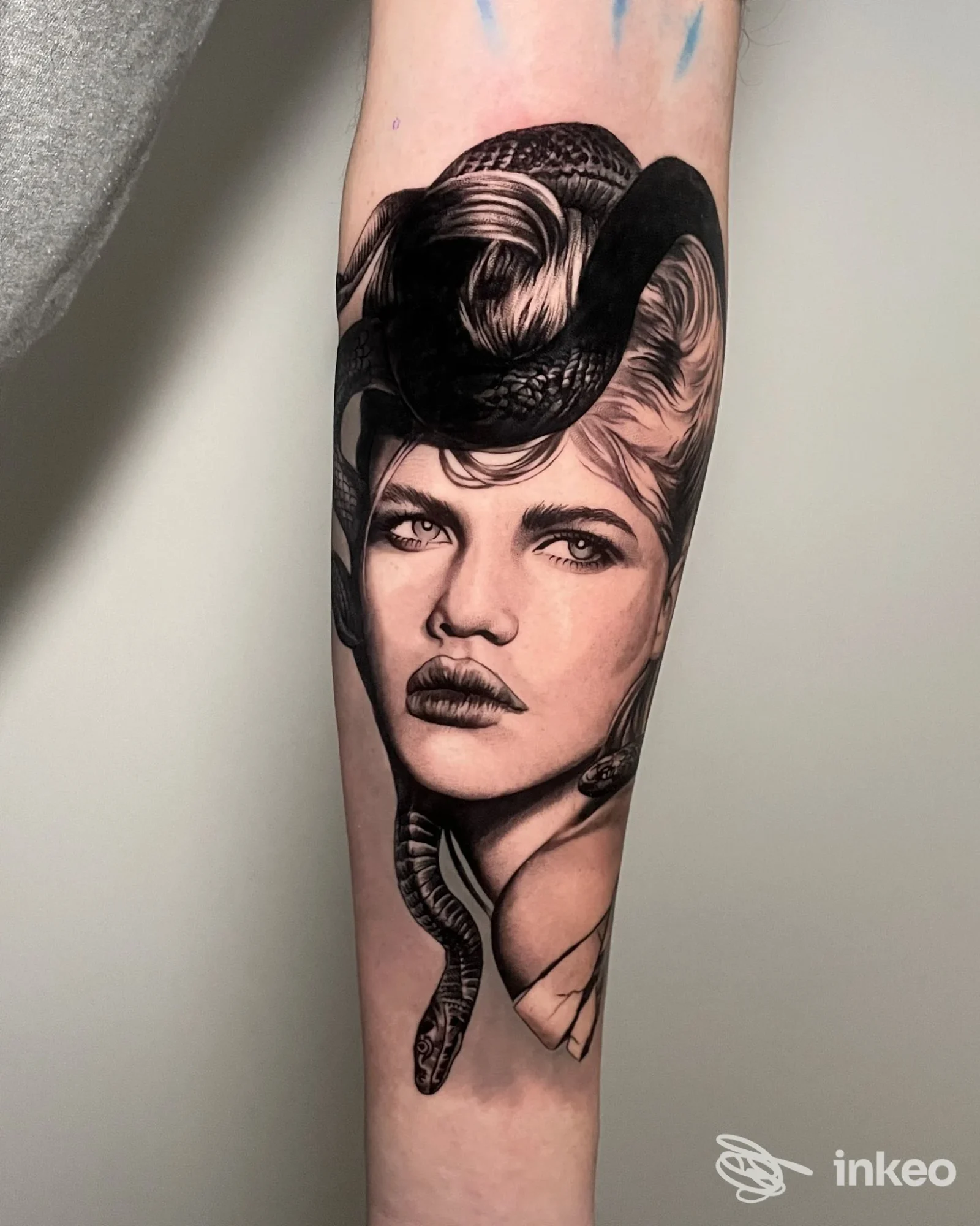 Tatuaggio realistico in bianco e nero su avambraccio con volto femminile e serpente, Little Tattoo Verona, Verona.