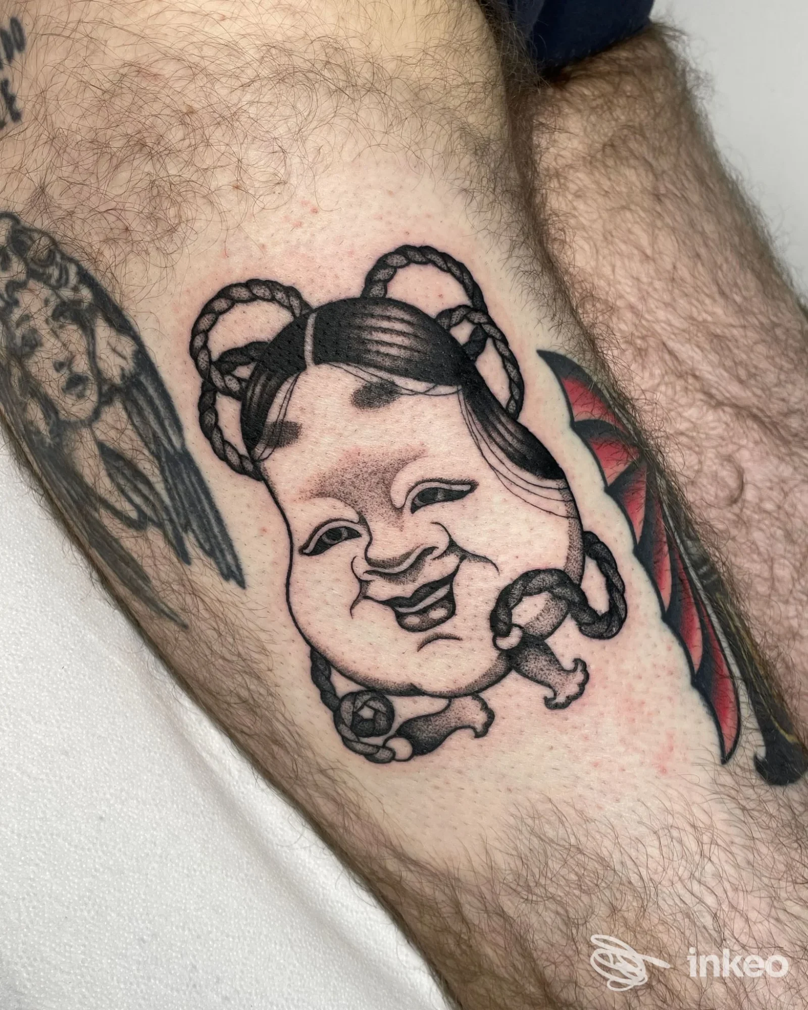 Tatuaggio fresco su polpaccio con volto stilizzato, MadSurgery Tattoo a Preganziol.