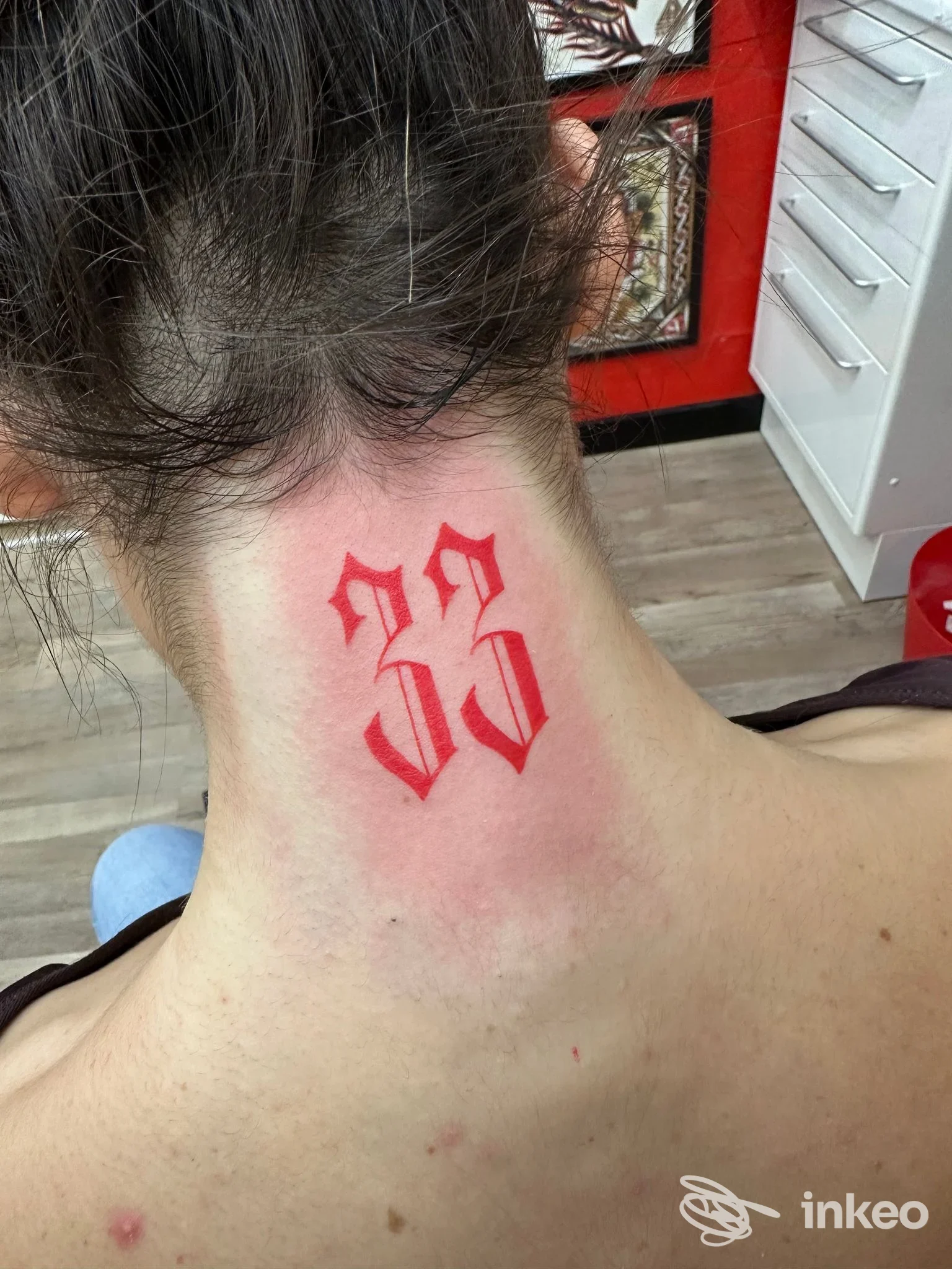 Tatuaggio in rosso con due caratteri gotici sulla nuca, foto dello studio NOTconventionalTATTOO a Vittorio Veneto.