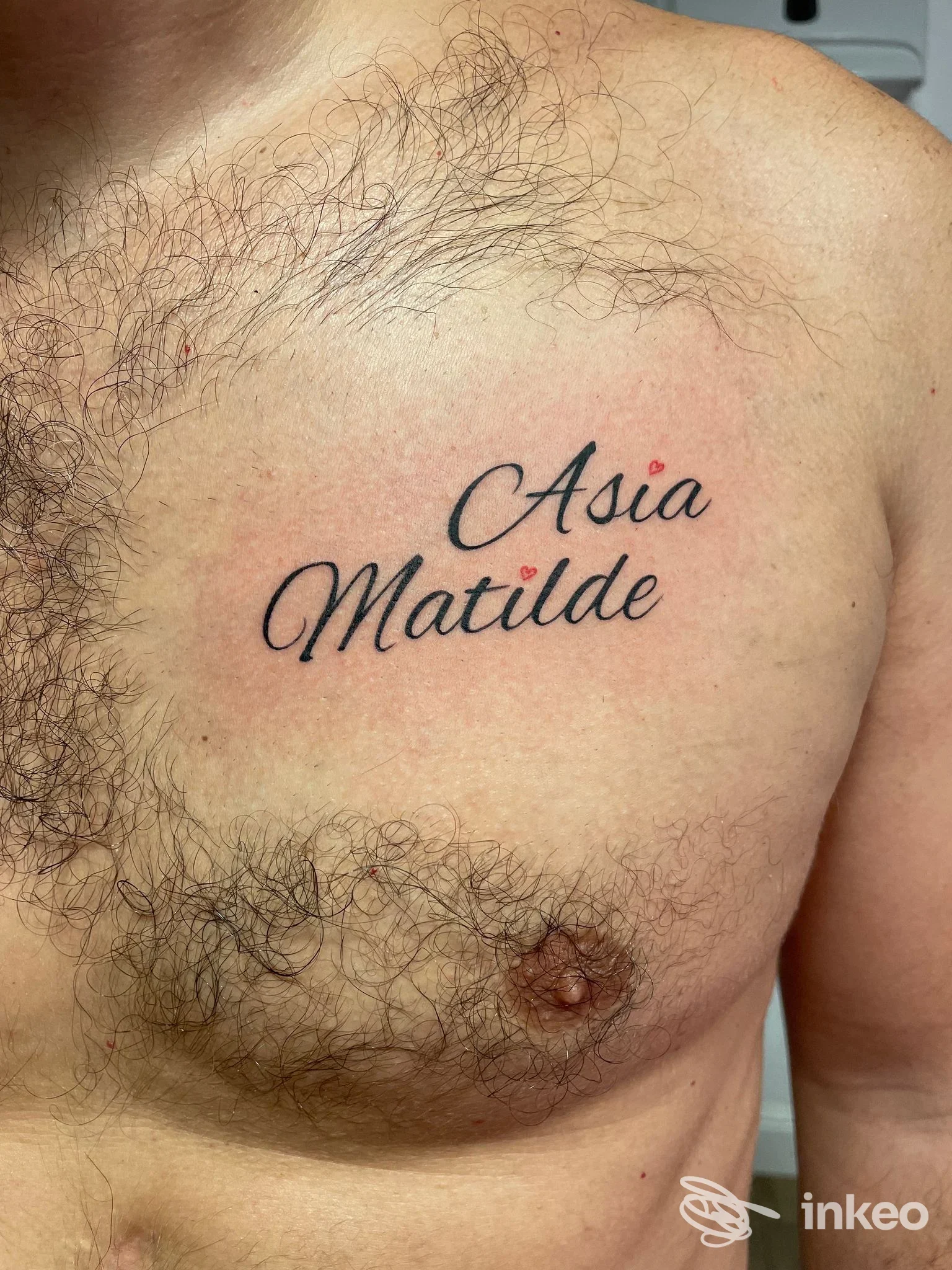 Tatuaggio con i nomi “Asia” e “Matilde” in corsivo sul lato sinistro del petto, eseguito da NiMa Piercing Tattoo, Asolo.