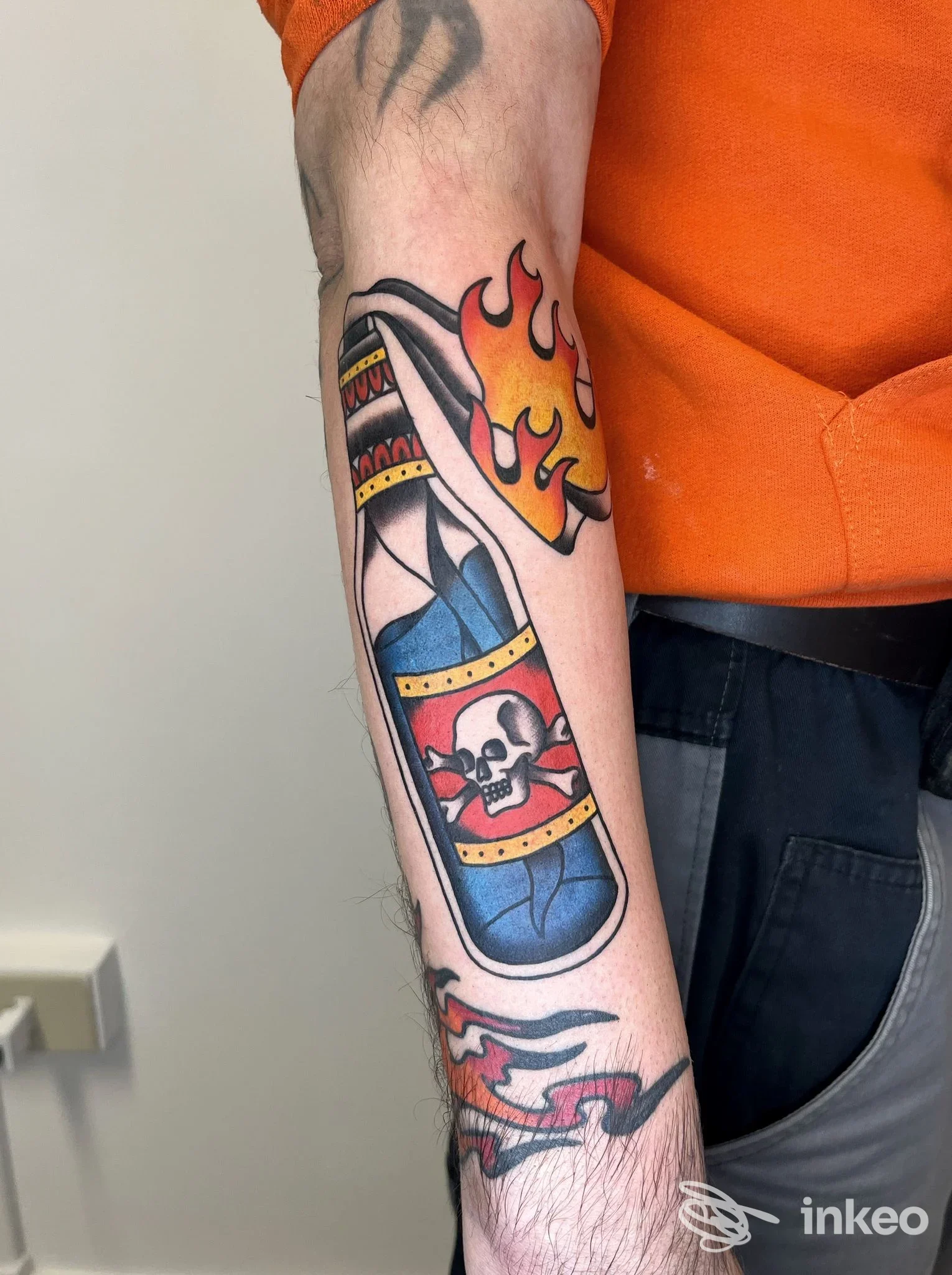 Avambraccio con tatuaggio colorato a bottiglia e teschio con fiamme, fotografato per Nonsense Tattoo di Alessandro Marangon a Mira.