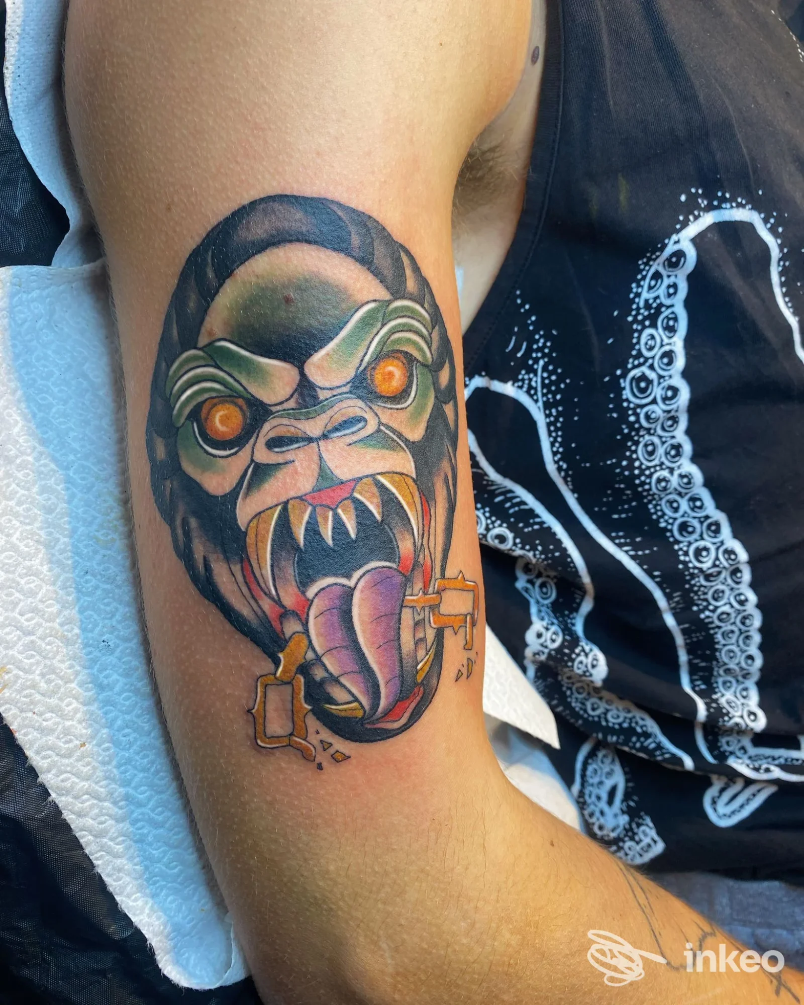 Tatuaggio colorato di una testa mostruosa sul bicipite, realizzato presso Oldline Tattoo Studio a Sandrigo.
