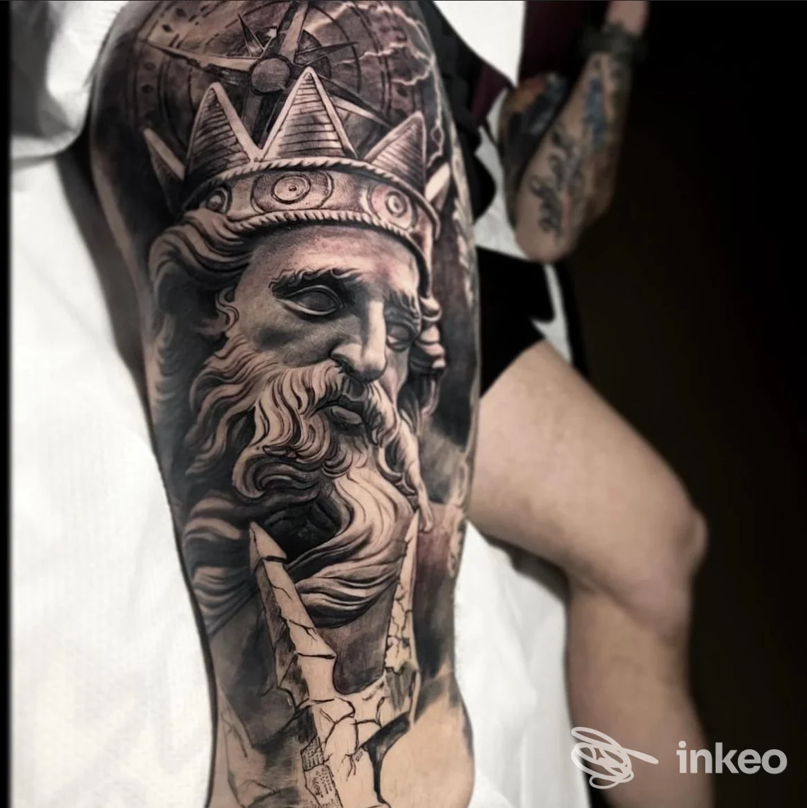 Tatuaggio realistico sul corpo con volto coronato e tridente, opera condivisa da STUDIO MURH TATTOO, Arlesega.