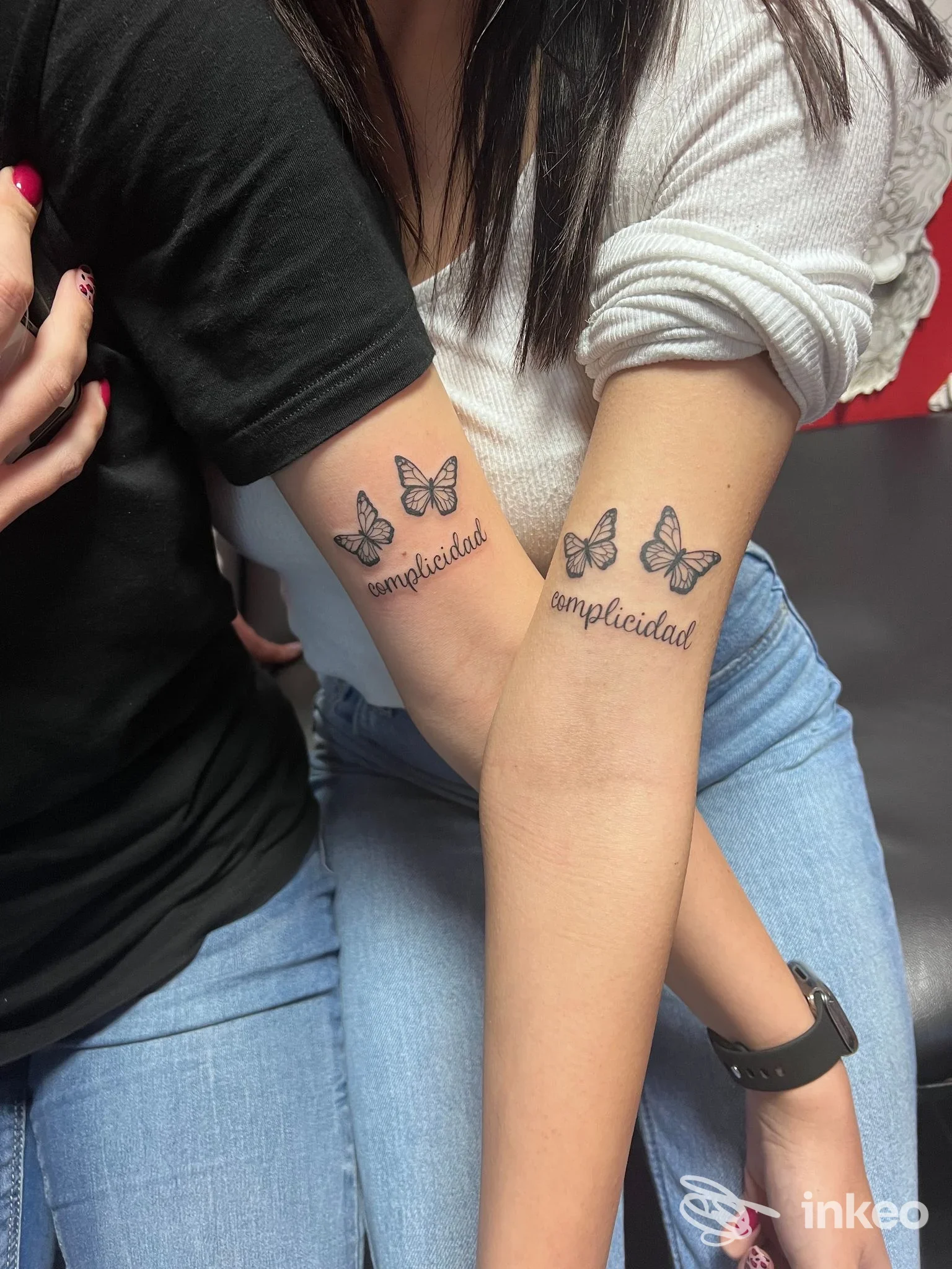 Due avambracci con tatuaggi di farfalle e la parola simplicidad, eseguiti sulla pelle, nello stesso braccio, in studio di tatuaggi Neverland Tattoo.
