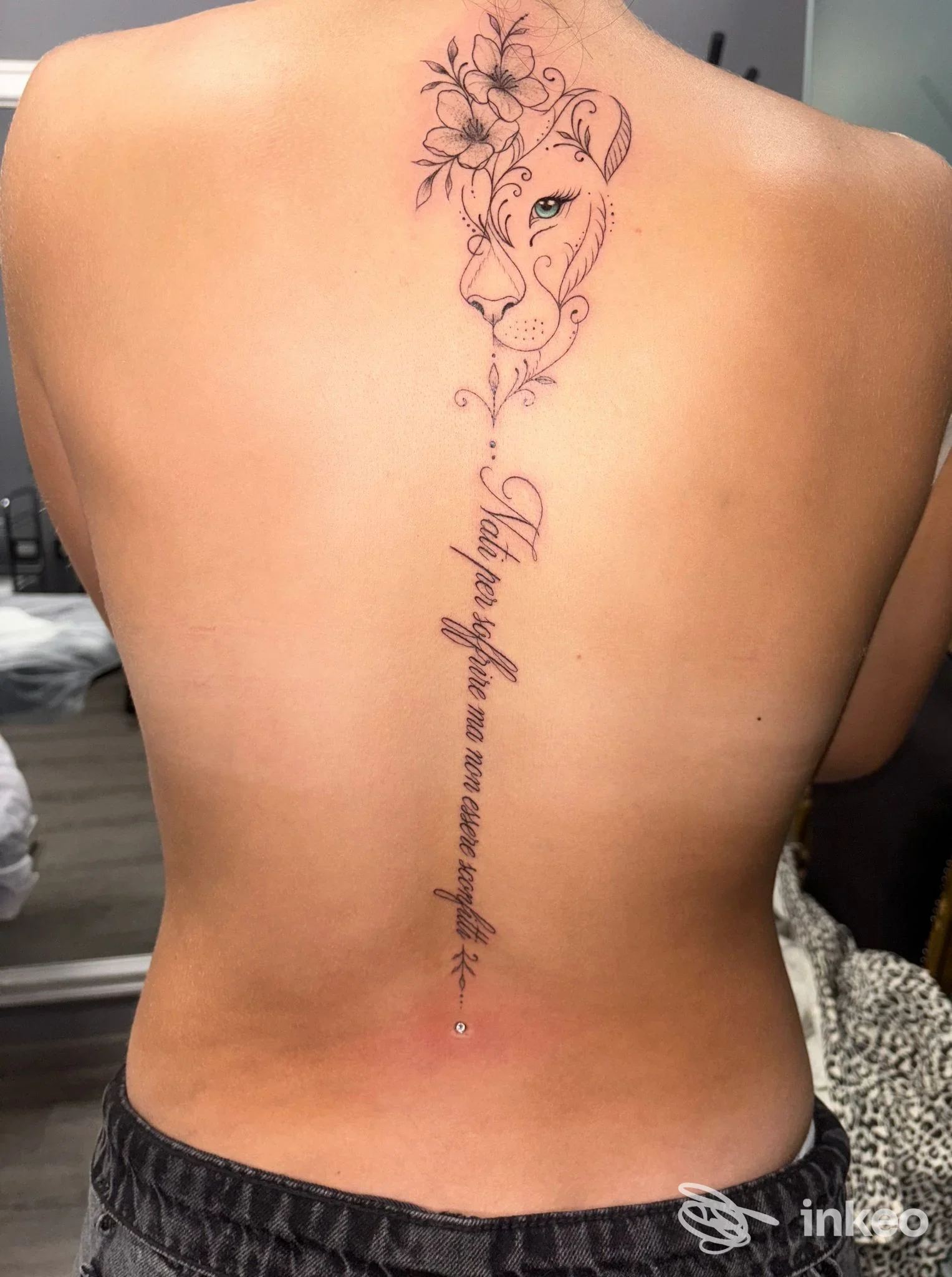 Tatuaggio lungo sulla colonna vertebrale con testa di leone floreale e scritta, Old Ink Tattoo Studio, Rovigo.