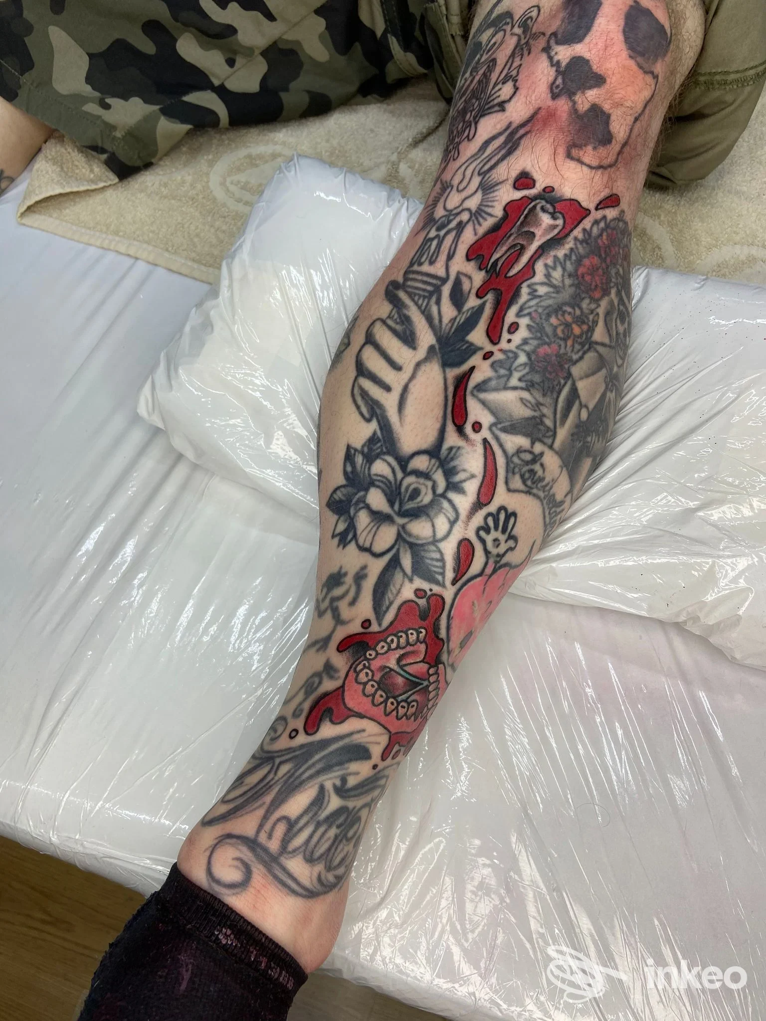Avambraccio tatuato con fiori e dettagli rossi, foto dello studio Pain[t] of Mind - Tatuaggi Personalizzati a Montegalda.