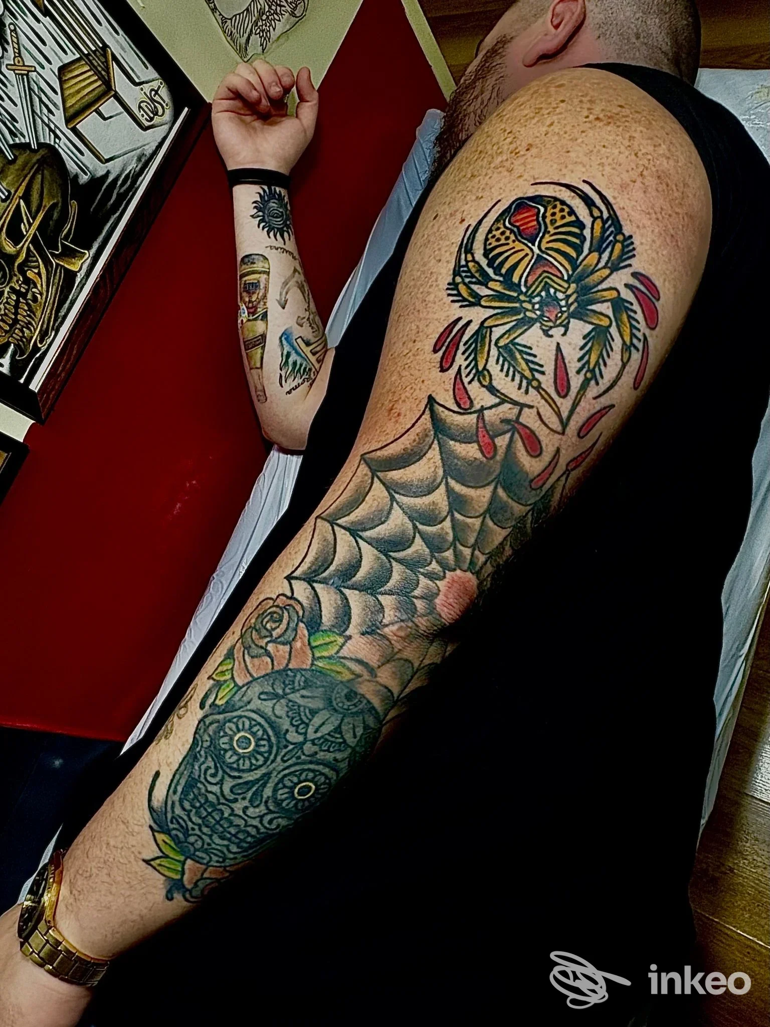 Braccio con manica di tatuaggi colorati, tra cui ragno, ragnatela e teschio decorativo; immagine dallo studio Pain[t] of Mind, Montegalda.