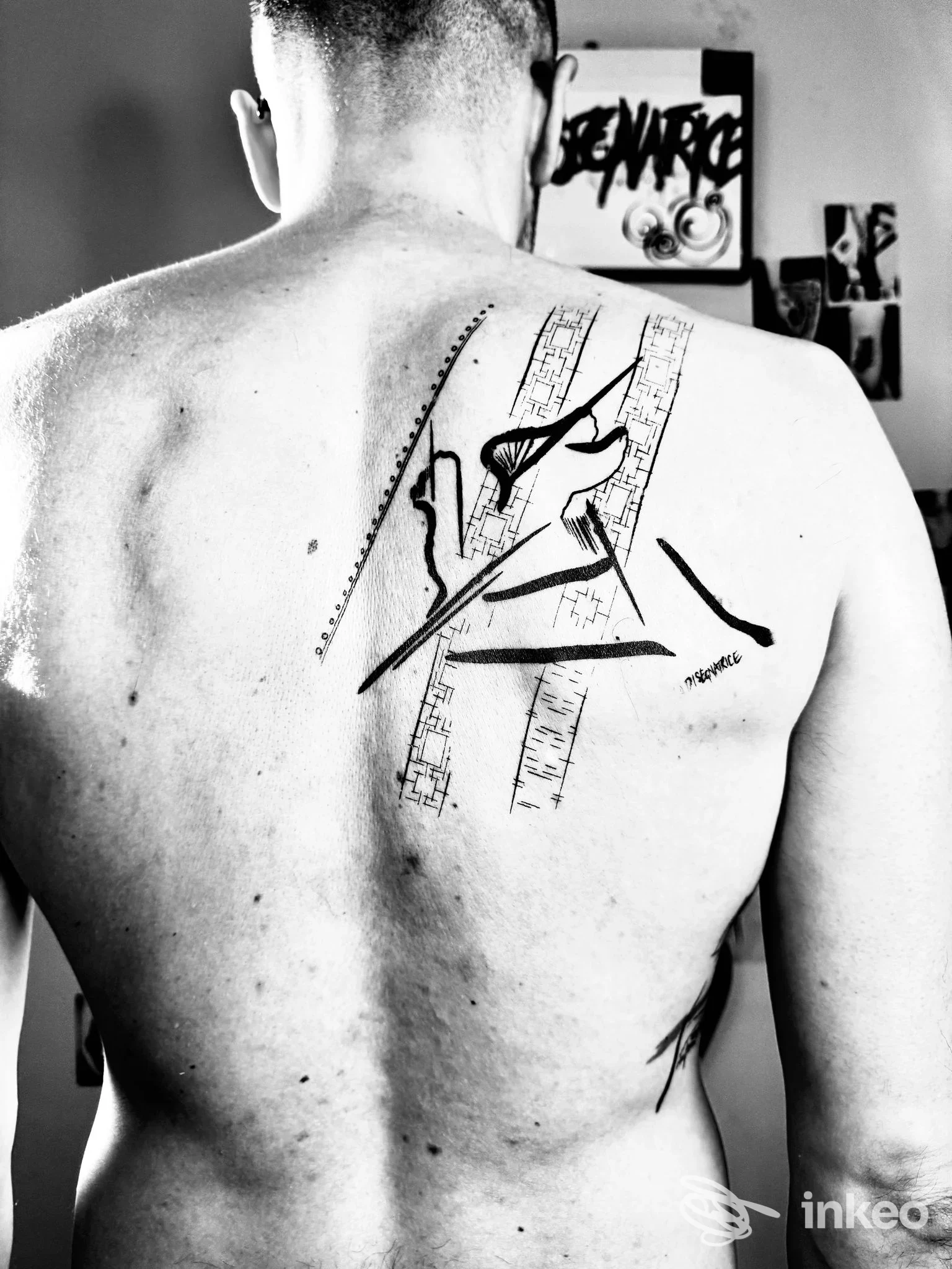Schiena di una persona con tatuaggio grafico a inchiostro nero sulla scapola destra. Studio Tattoo LA DISEGNATRICE, Trissino.