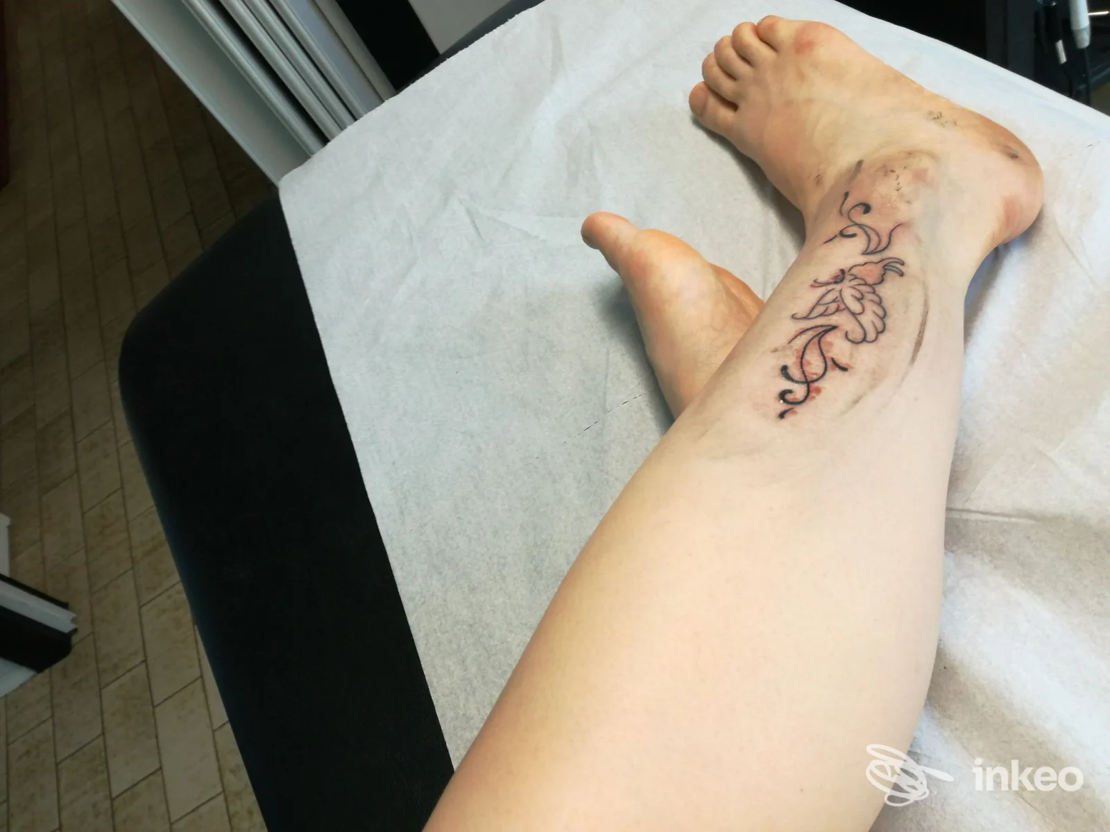 Tatuaggio ornamentale fresco sulla tibia di una persona, foto realizzata da Tattoo Shock a Ponte Nelle Alpi, primo piano sul lettino.