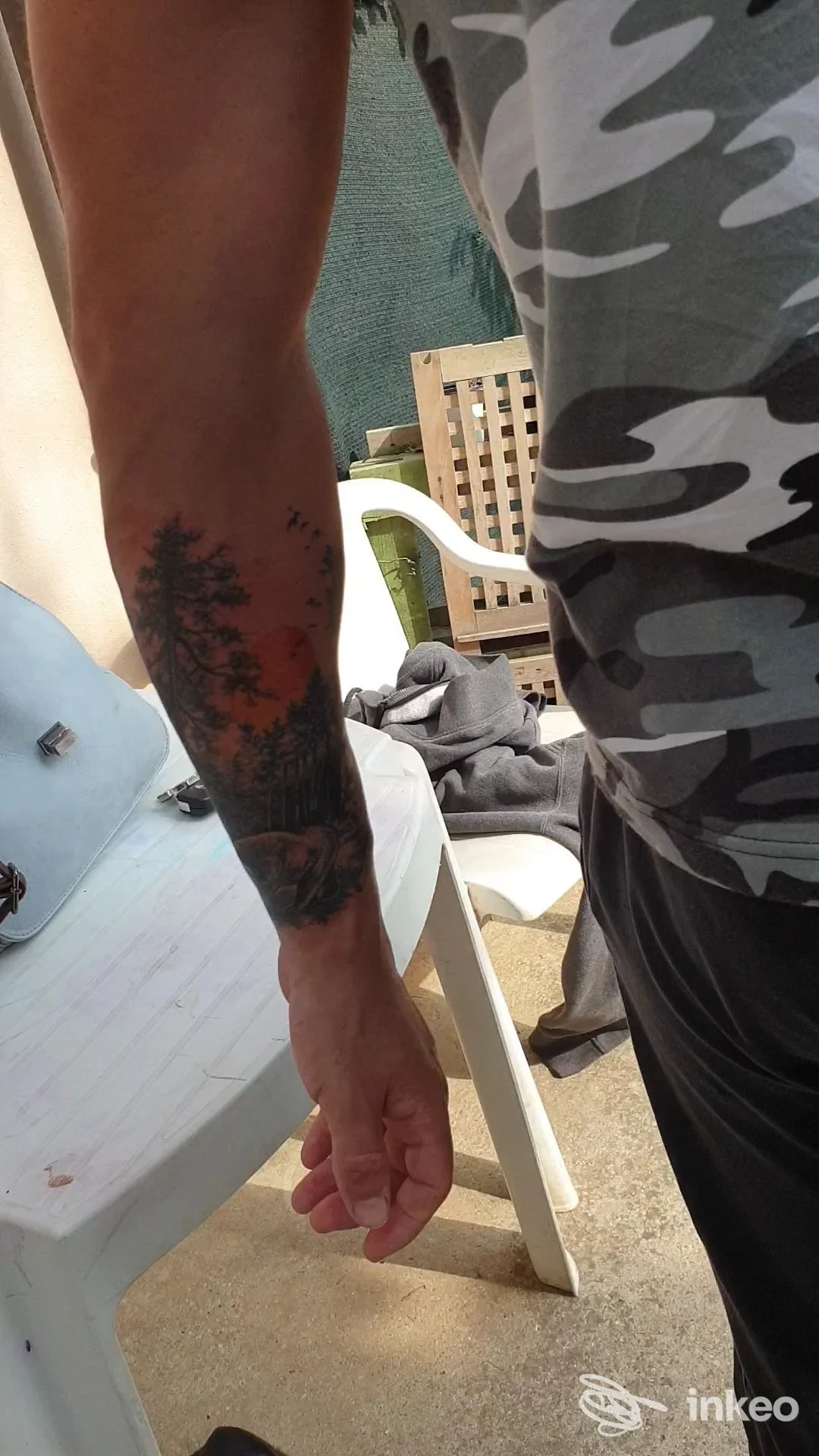 Primo piano di un avambraccio tatuato con motivo scuro e dettagli paesaggistici, foto fornita da Skin Painting Tattoo, Saccolongo.