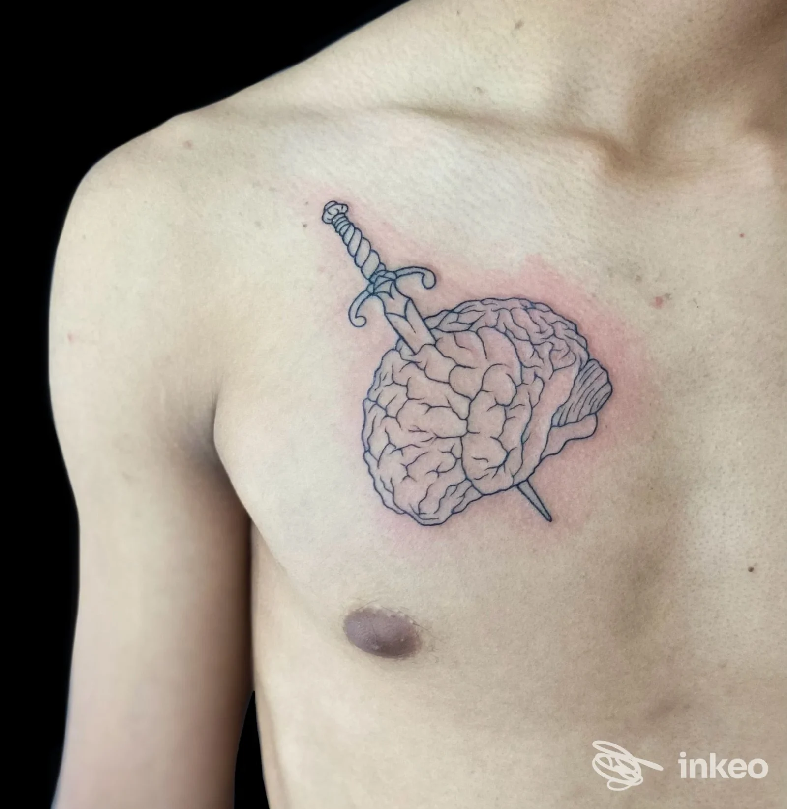 Tatuaggio di un cervello trafitto da una spada sul petto sinistro, foto dello studio The Chico's tattoo a Rosà.