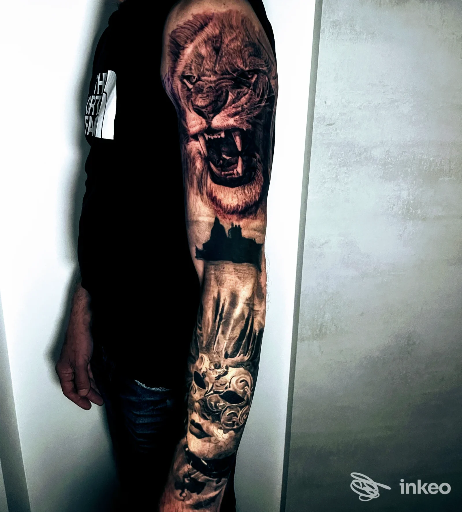 Manica completa con leone realistico sul braccio di una persona, fotografata in interno. The Saloon Tattoo Studio, Venezia.