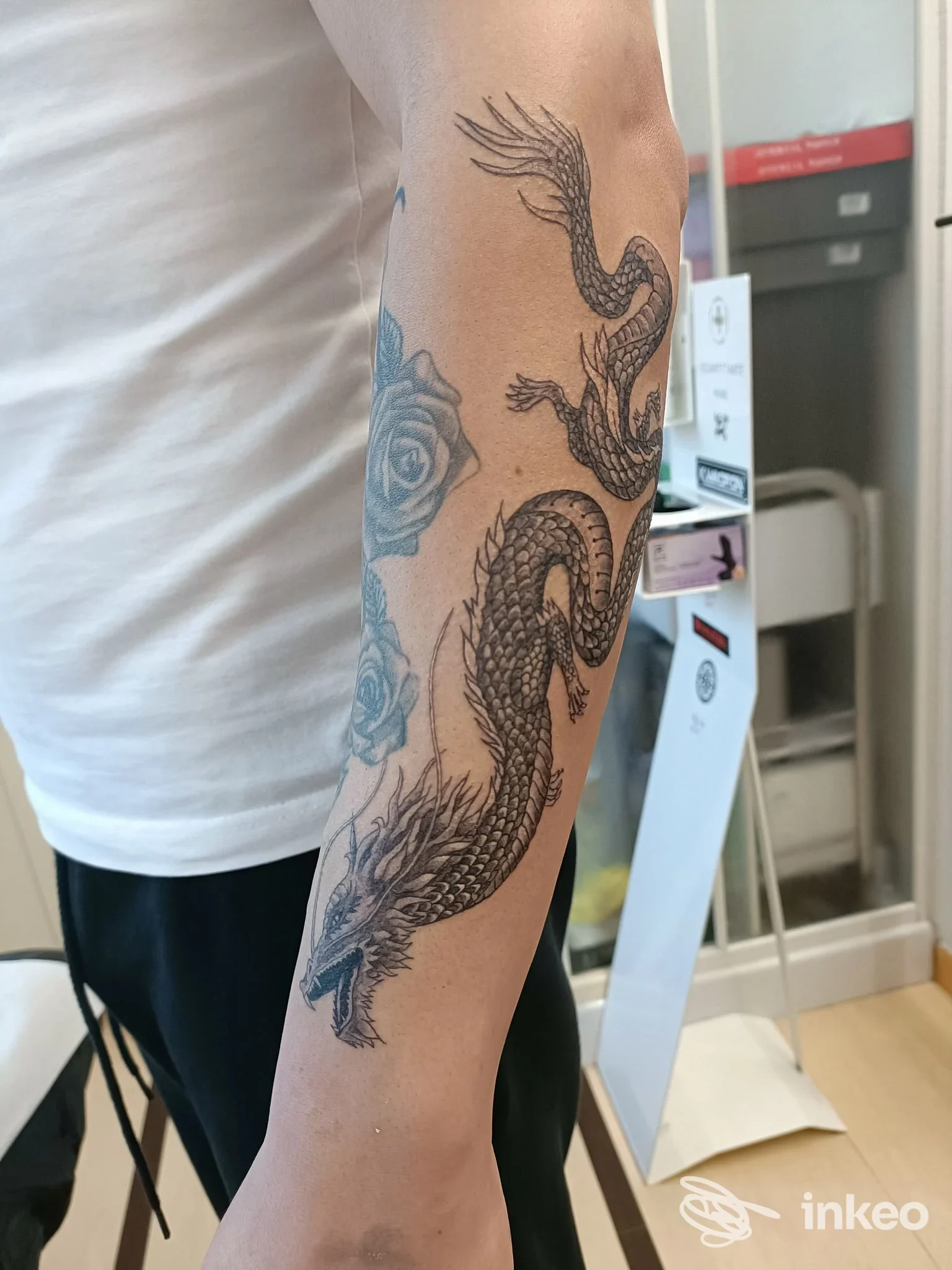 Tatuaggio drago nero sull'avambraccio con rose, fotografia scattata nello studio Zerbi Tattoo a Mogliano Veneto.