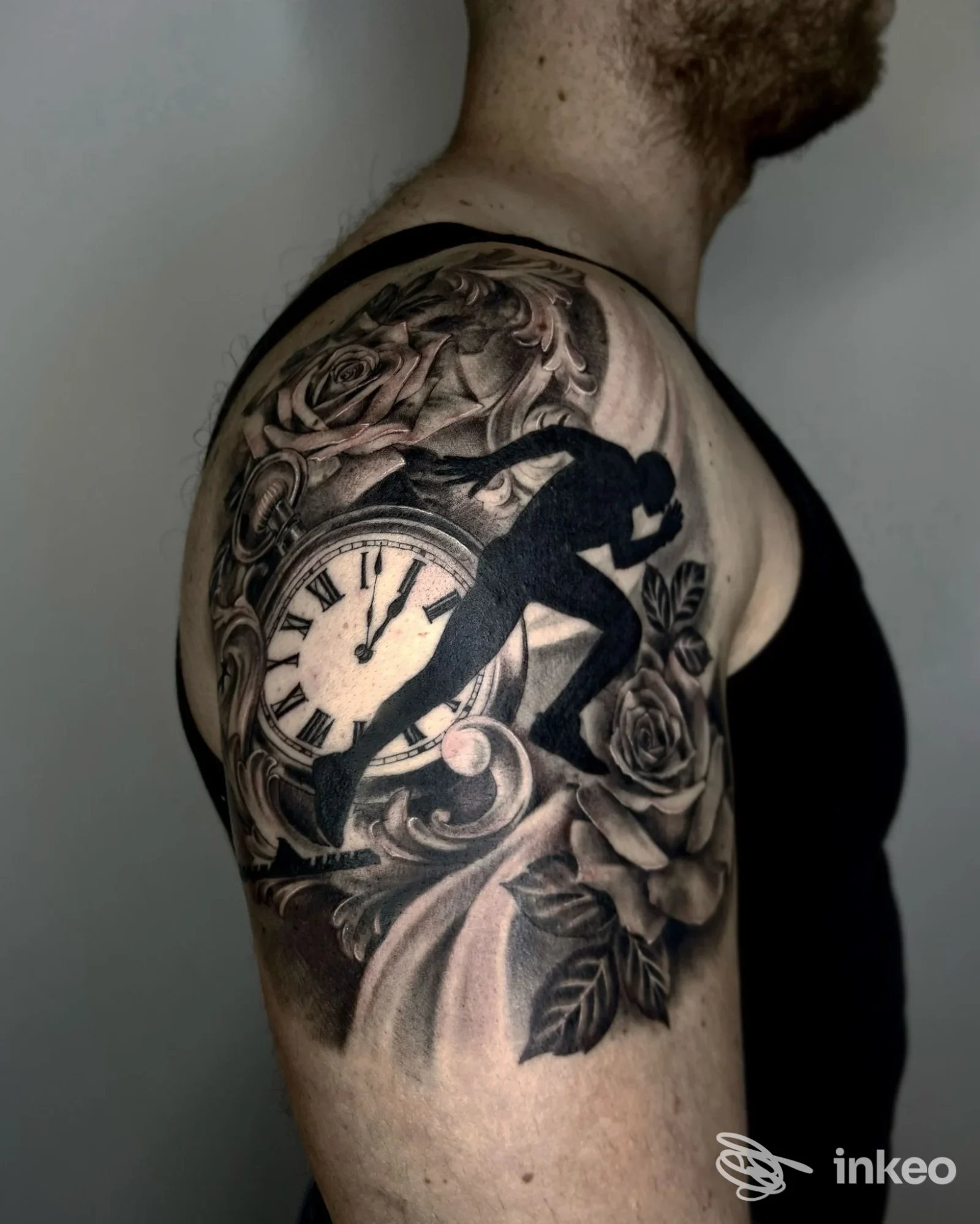 Tatuaggio realistico su spalla e braccio con orologio, silhouette e rose, fotografia di Arte Tattoo Studio a Matera.